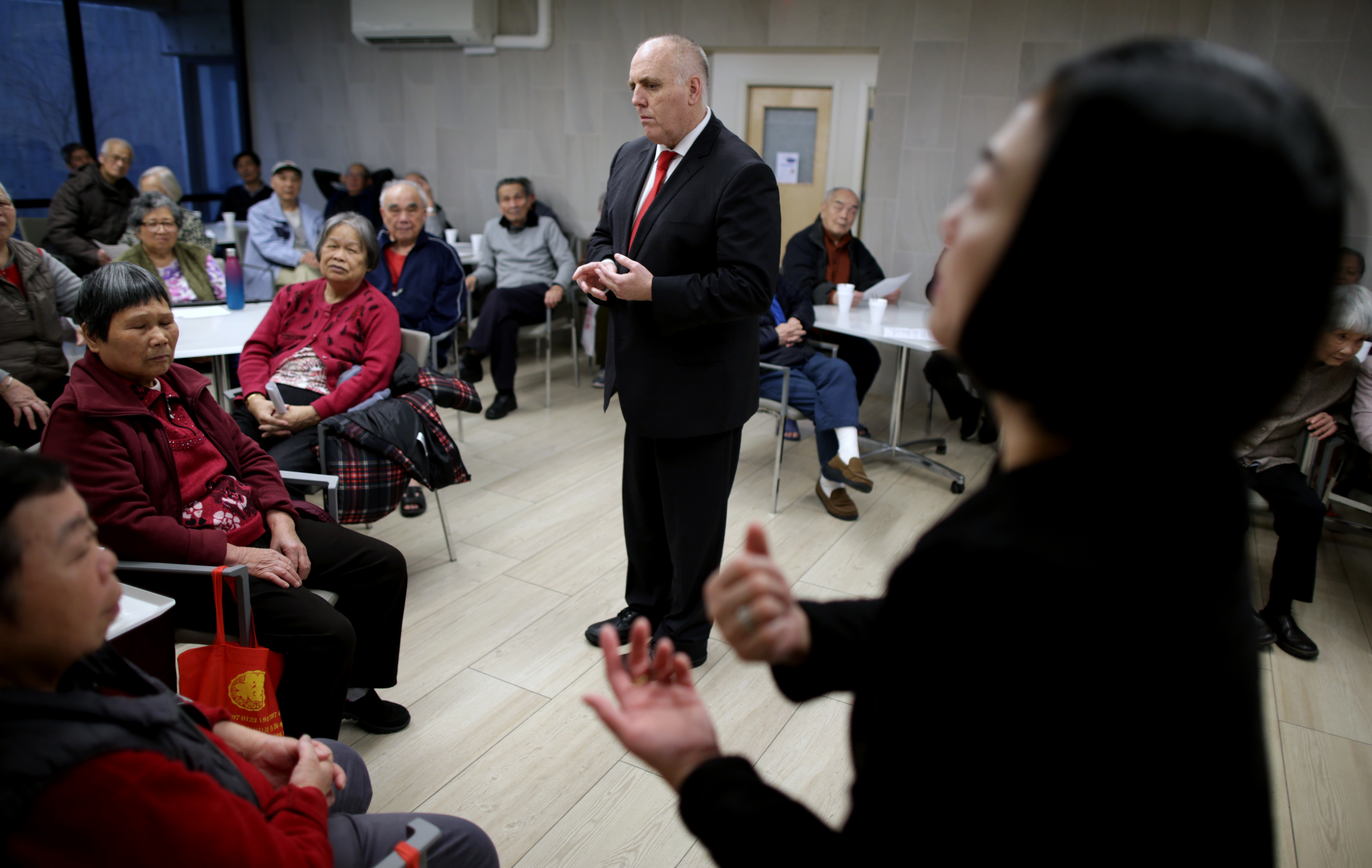Boston City Councilor Ed Flynn spoke with residents at Quincy Tower in Chinatown. At right was Megan Cheung, associate and clinical director of the Greater Boston Chinese Golden Age Center in Chinatown.