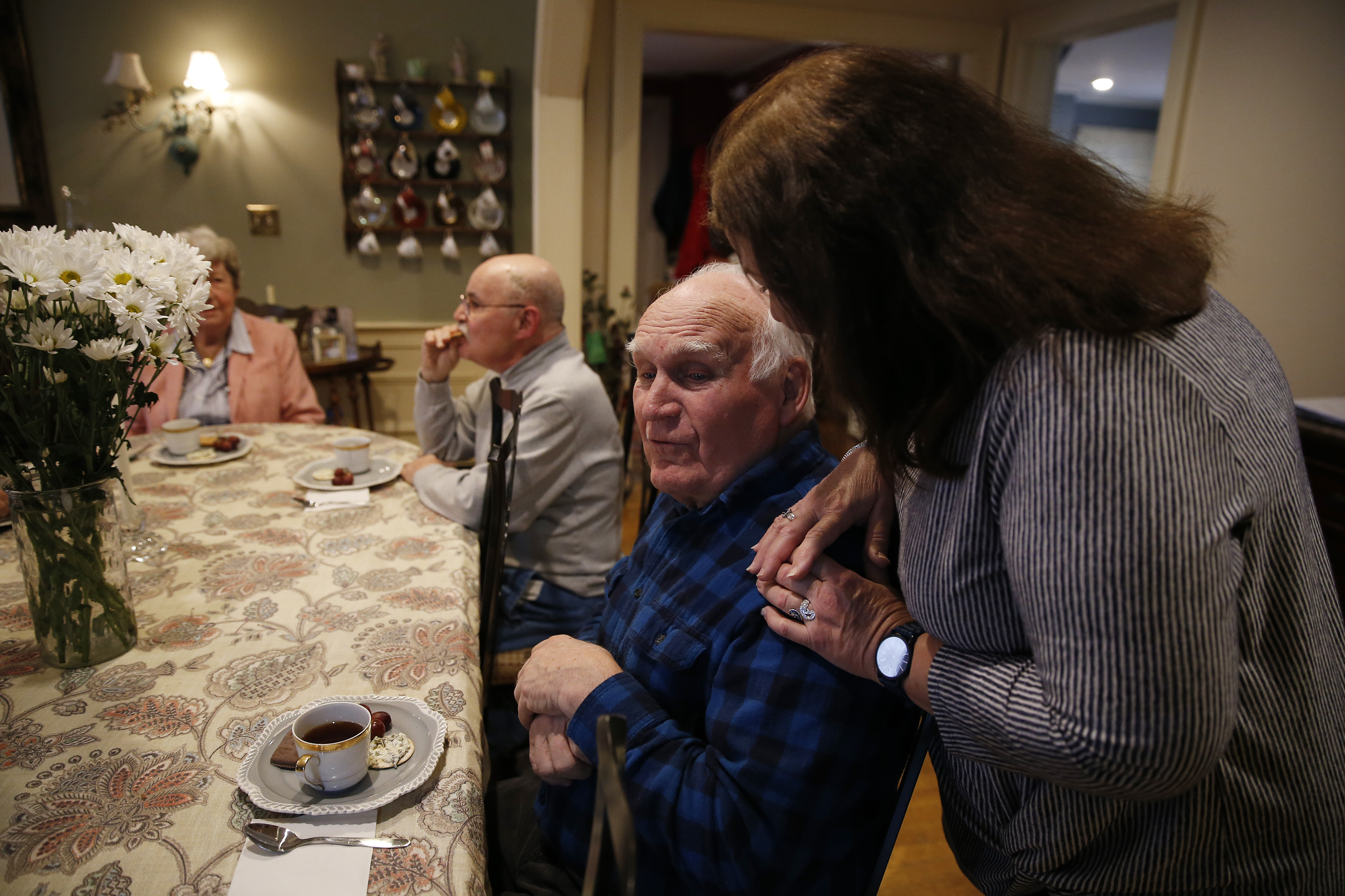 Program Assistant Gloria Cabral (right) chatted with William Sullivan during high tea at the Julia Ruth House Adult Day Care Center.