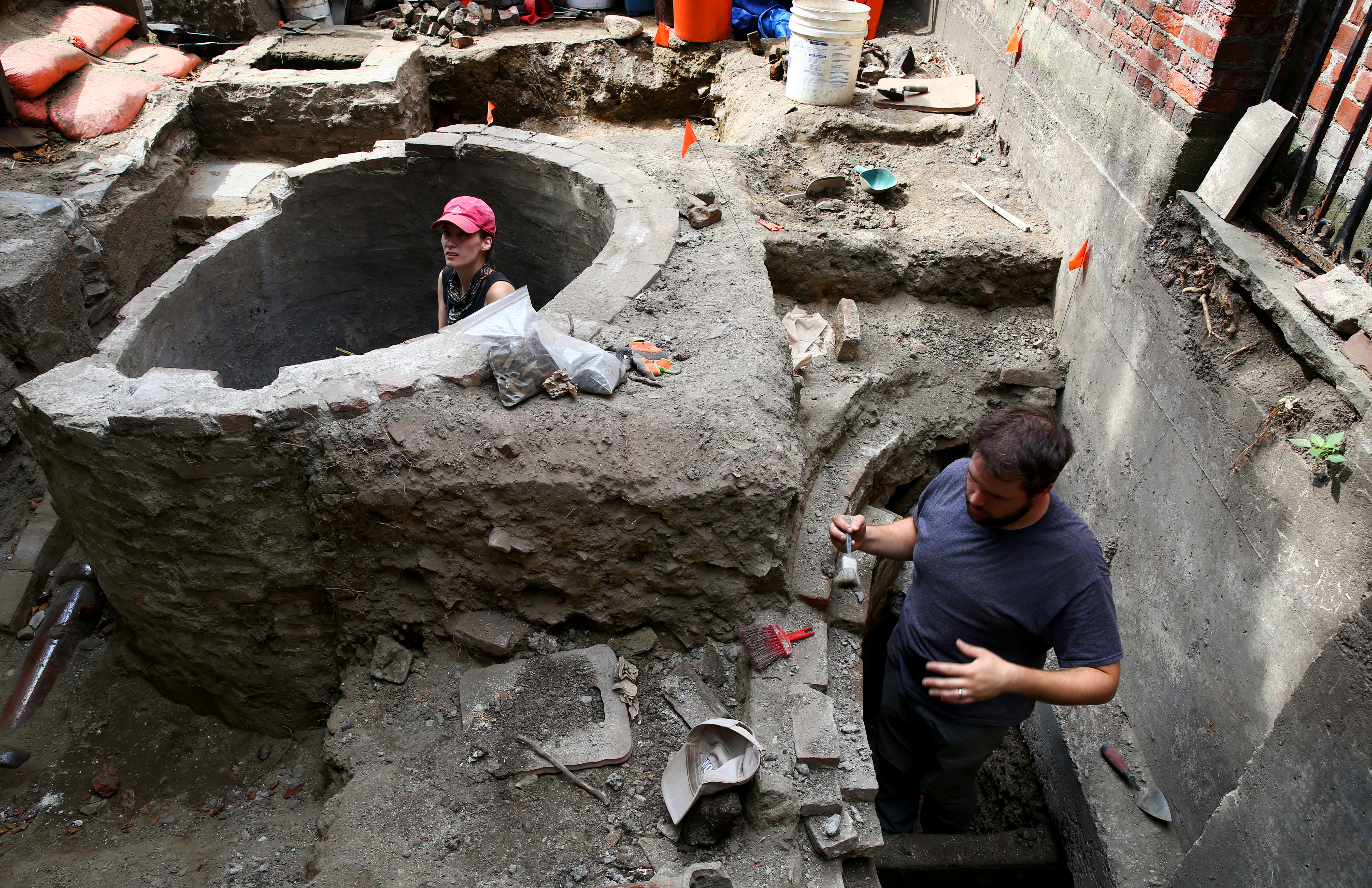 Archaeologist Elizabeth Neill (left) worked in the cistern while city archaeologist Joe Bagley worked in the privy.