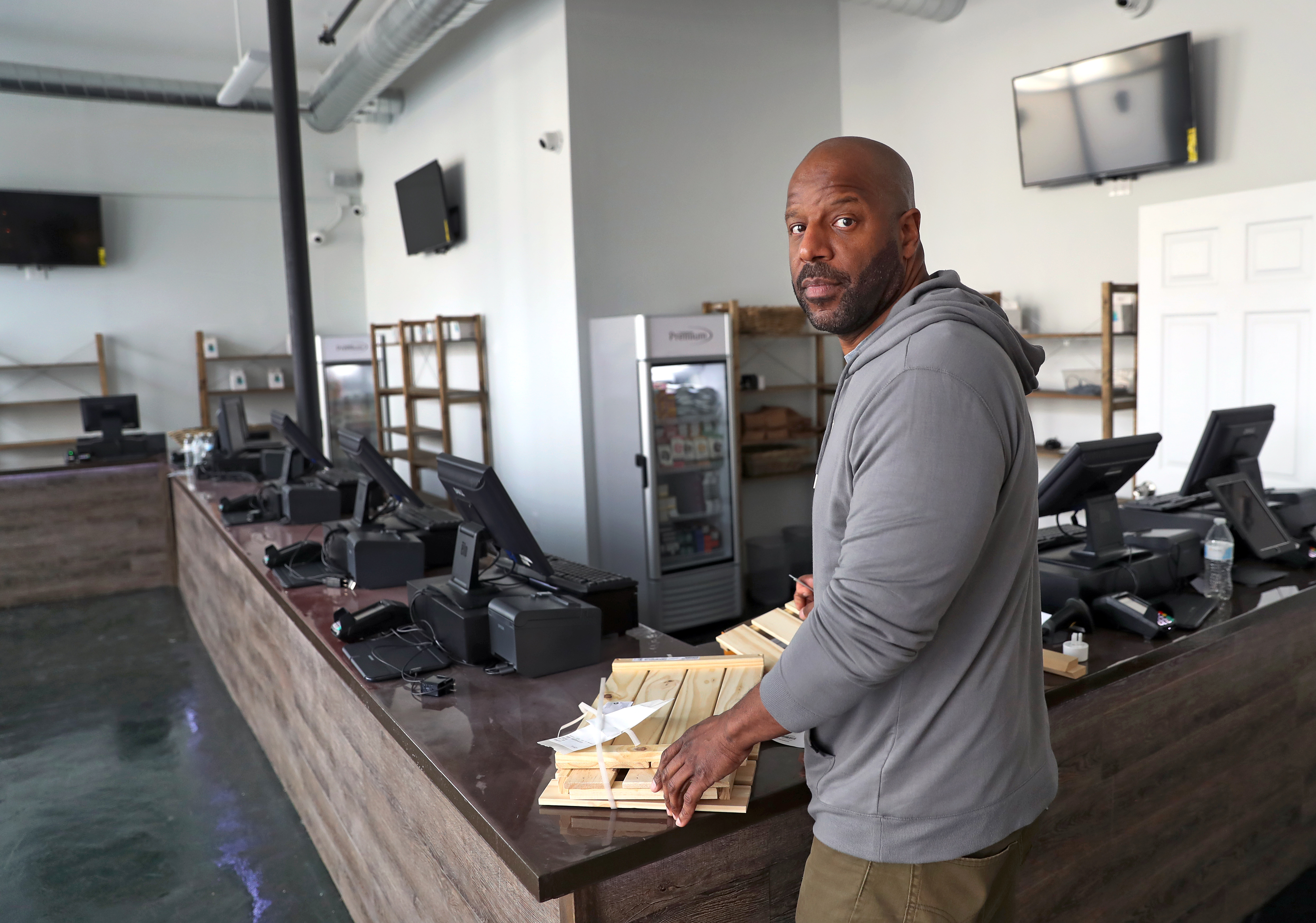 Pure Oasis co-owner Kobie Evans assembled Ikea shelves to hold pot products in Boston's first marijuana store, slated to open Monday.