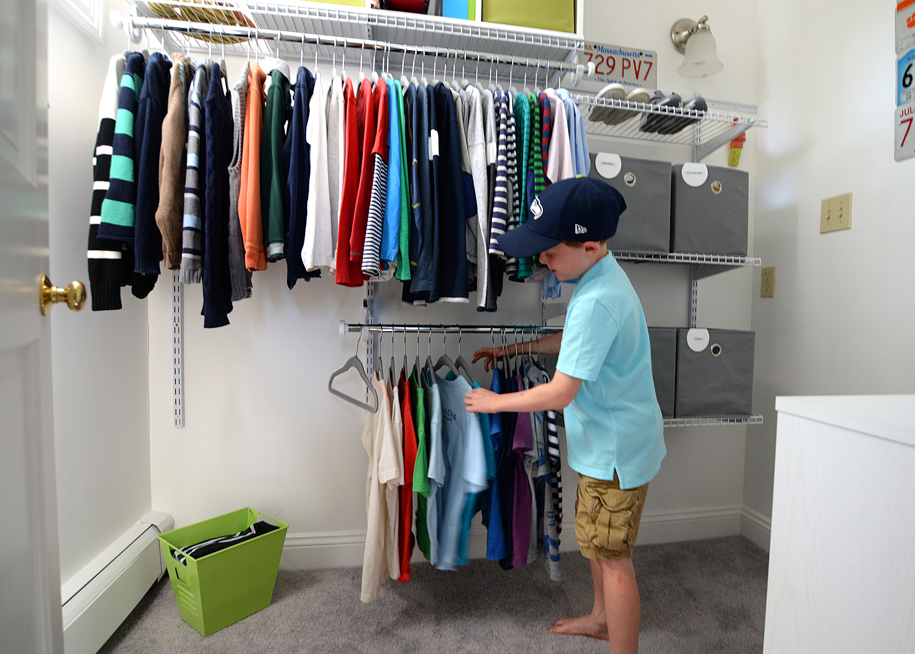 Hunter Maldonis, 8, looks at his shirts in the well-organized closet of his Scituate home.