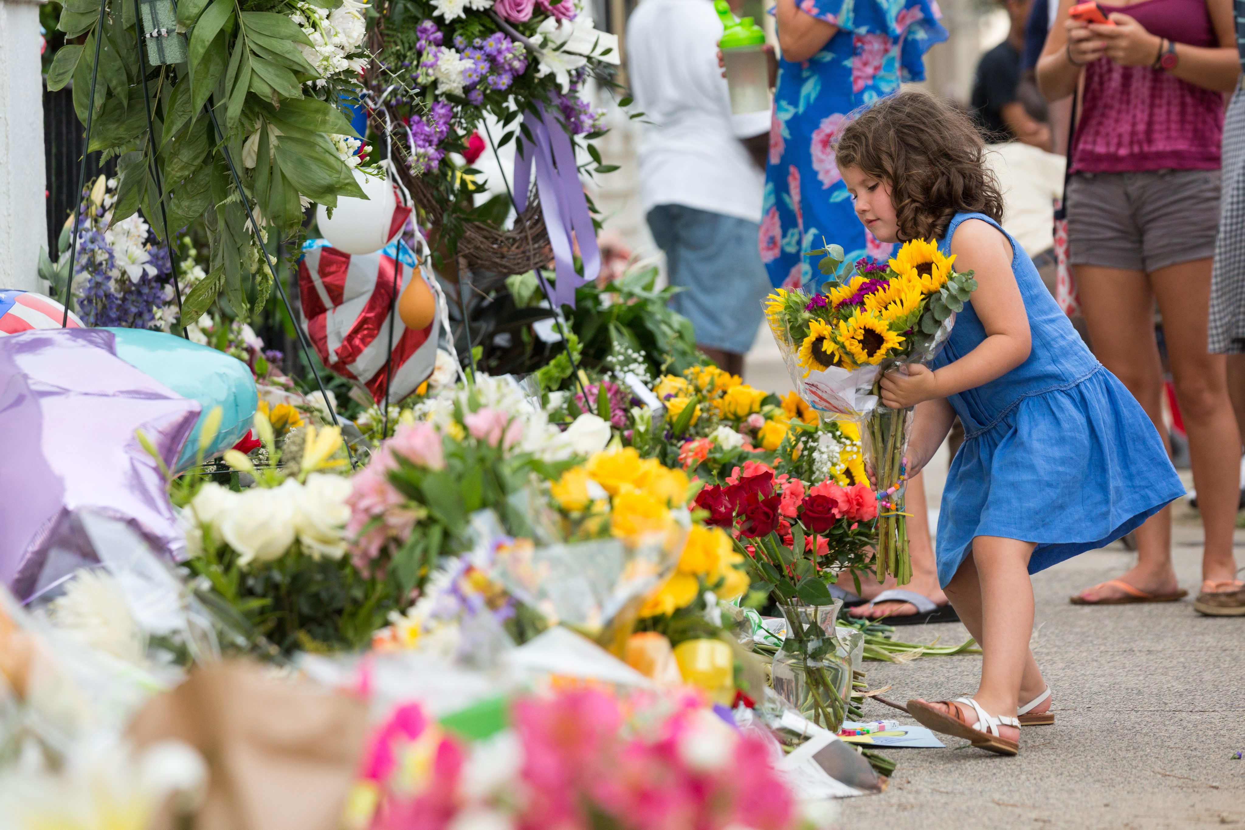 A young girl left flowers at the memorial outside the Emanuel African Methodist Episcopal Church on Friday.