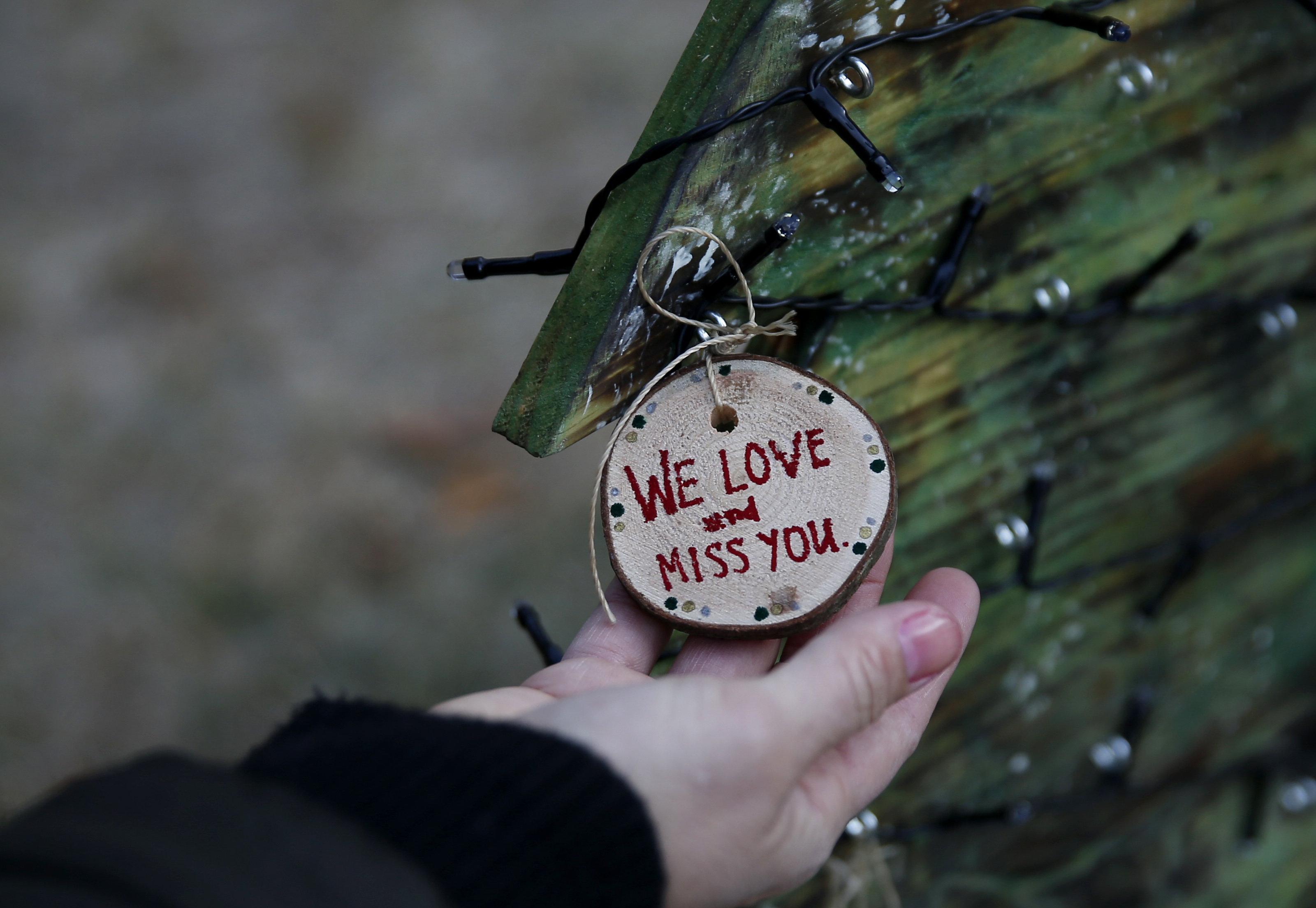 Shannon Goyette looked at an ornament left at her son Jacob's grave on a wooden Christmas tree she and her family made to rest beside it.