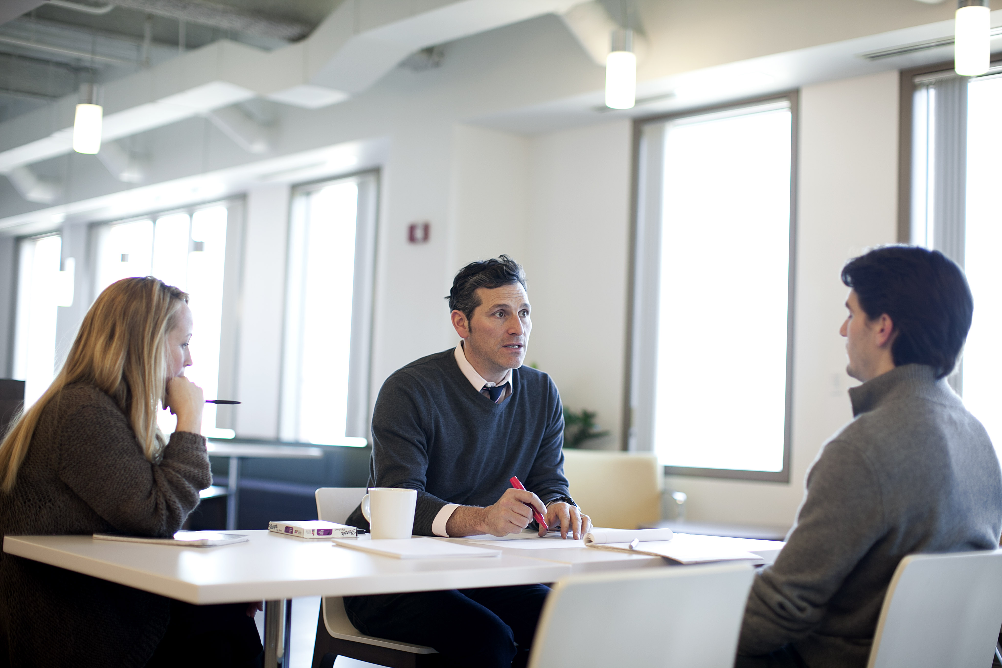 Joel Idelson (center), creator of opportunities, meets with Ross Chanowski, manager of opportunities, and Stacy McIntyre, new business coordinator, in the office of Allen&Gerritsen in Boston.
