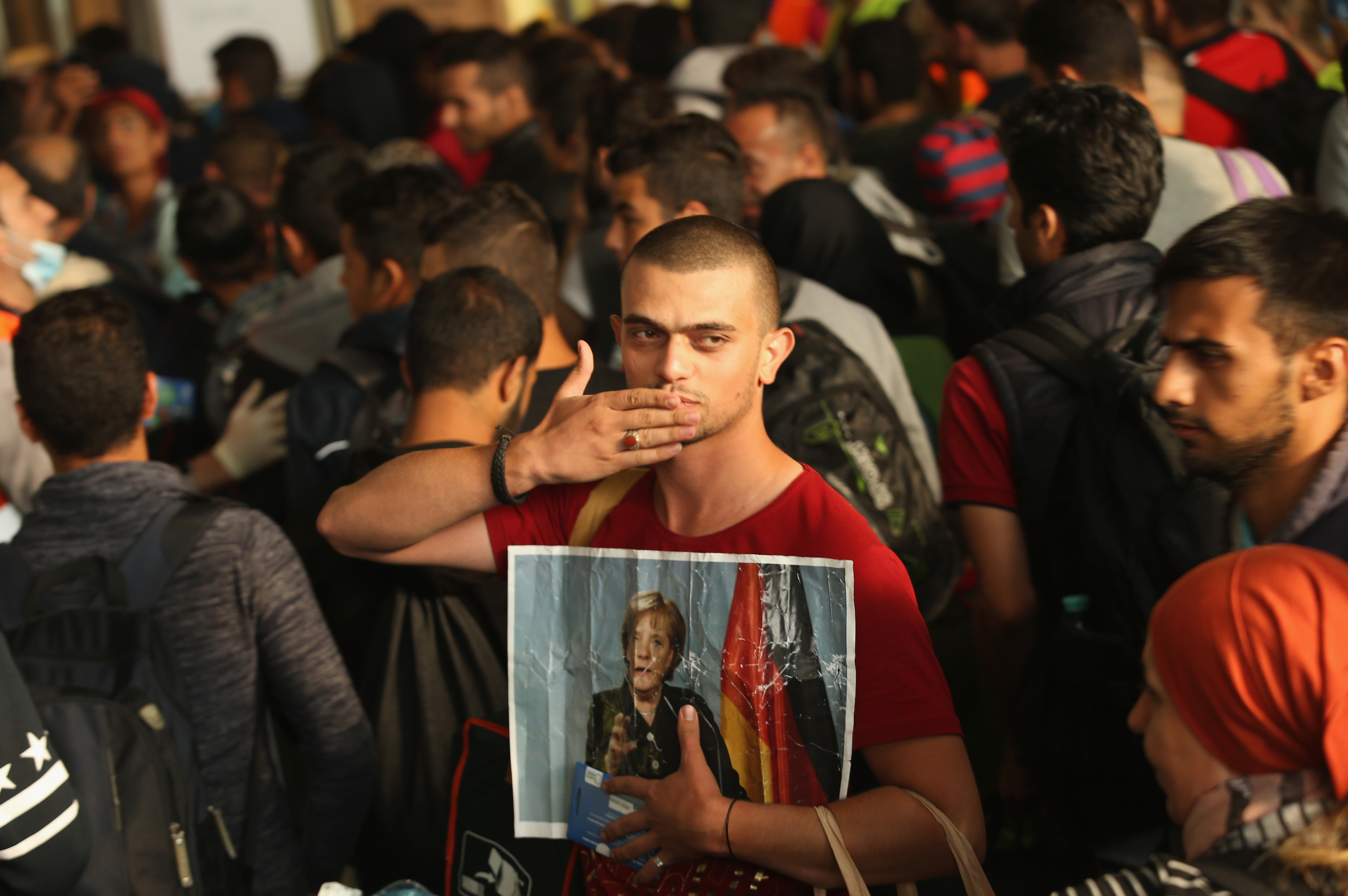A Syrian held a picture of German Chancellor Angela Merkel as he arrived in Munich on Saturday.