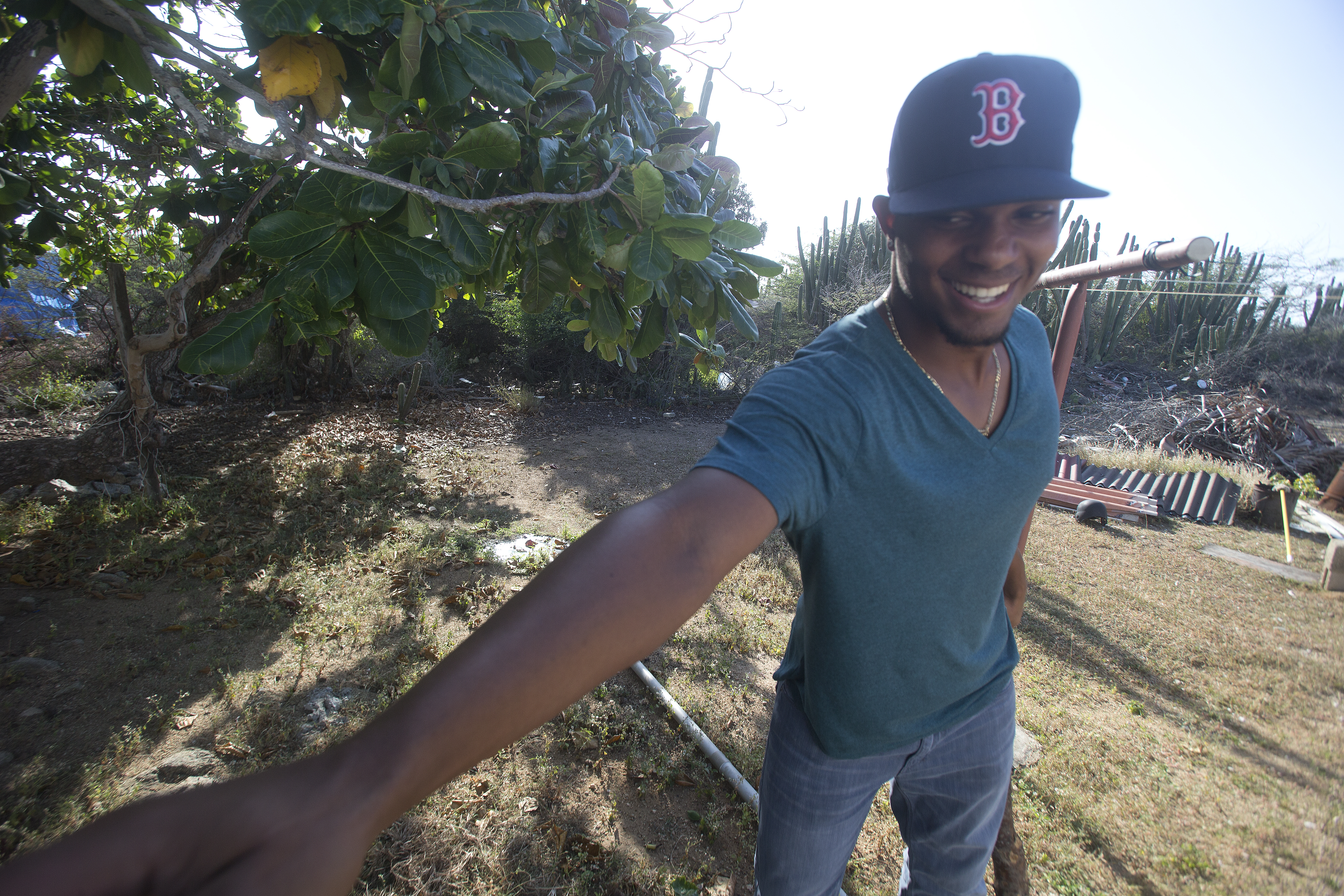Xander Bogaerts stands under the almond tree in his uncle's backyard where he learned how to play baseball as a boy.