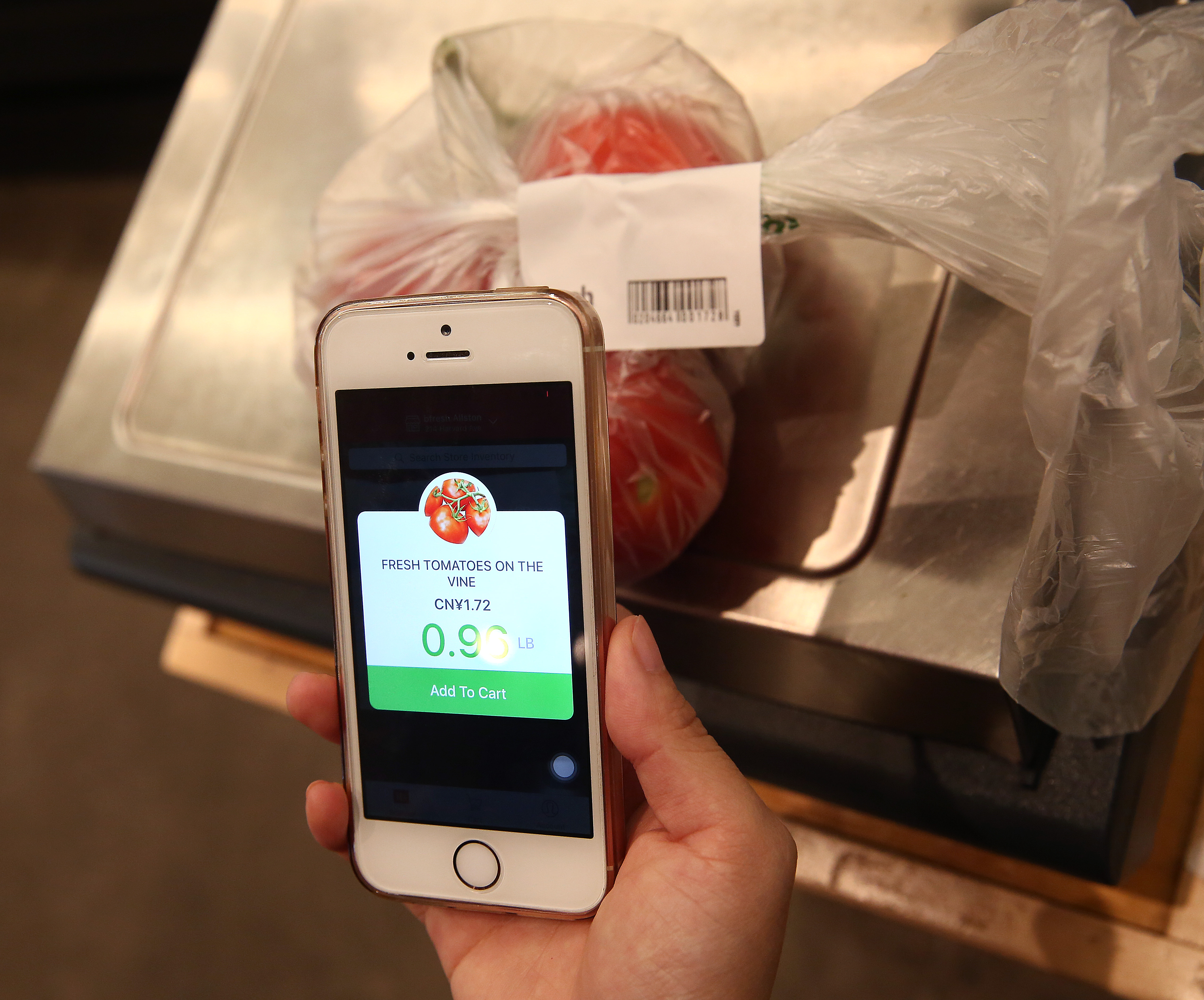 Mandy Xu weighed the tomatoes on a digital scale and then scanned the printed label.