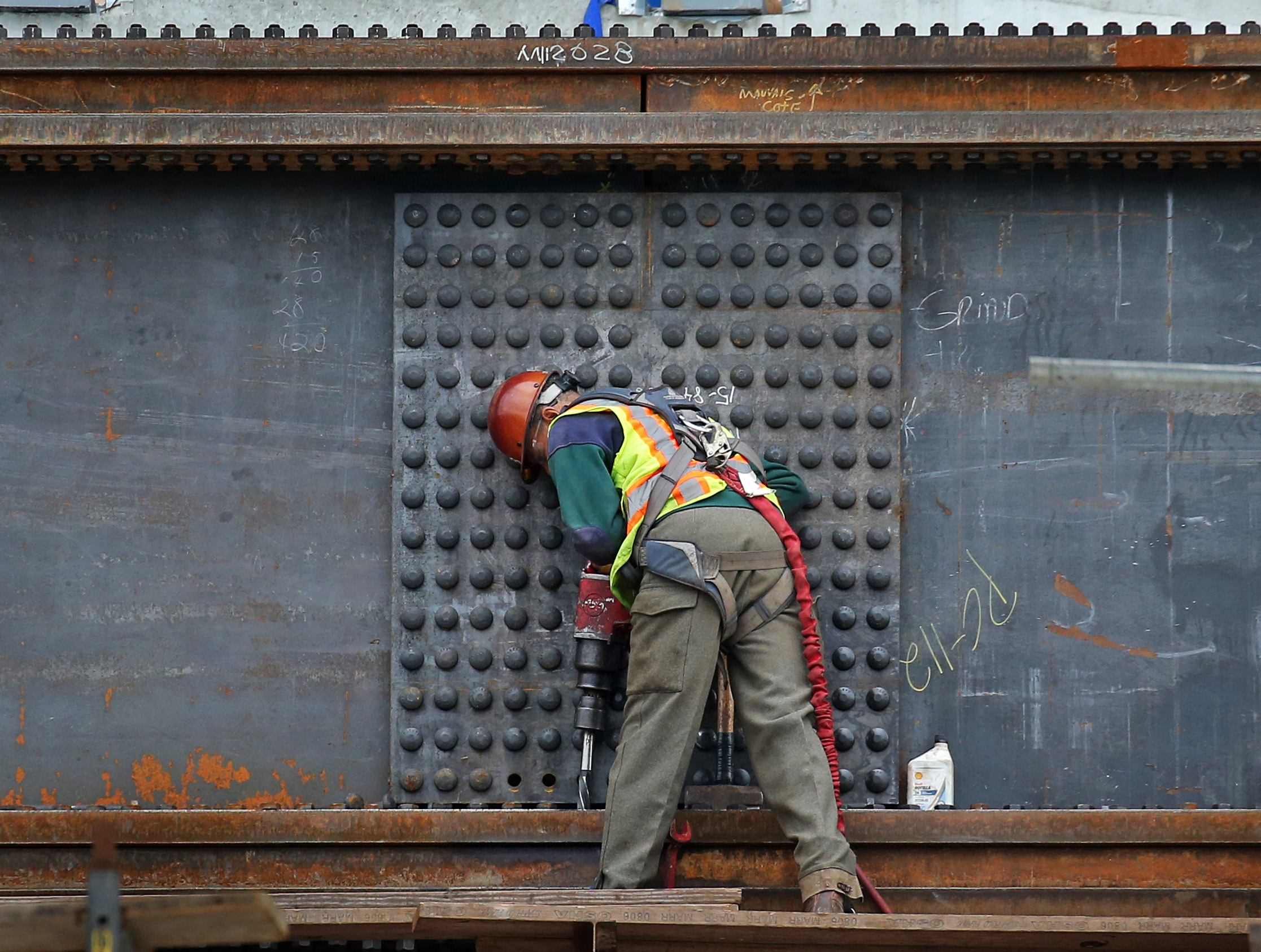 A construction worker working on steel.