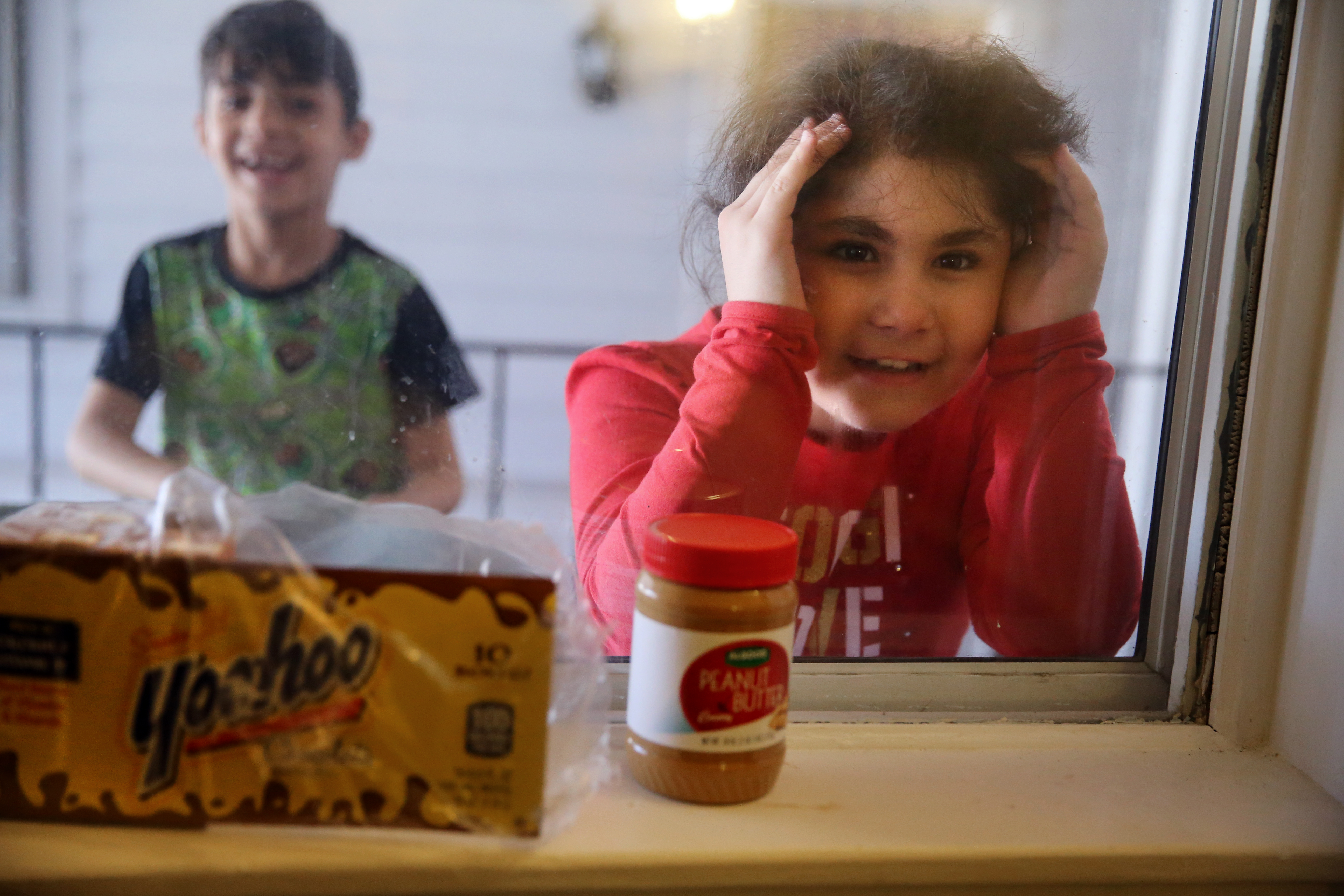 Twins Abdullah (left) and Fatimah al Rubaye peered into their room at the Colonial Traveler Inn in Saugus.