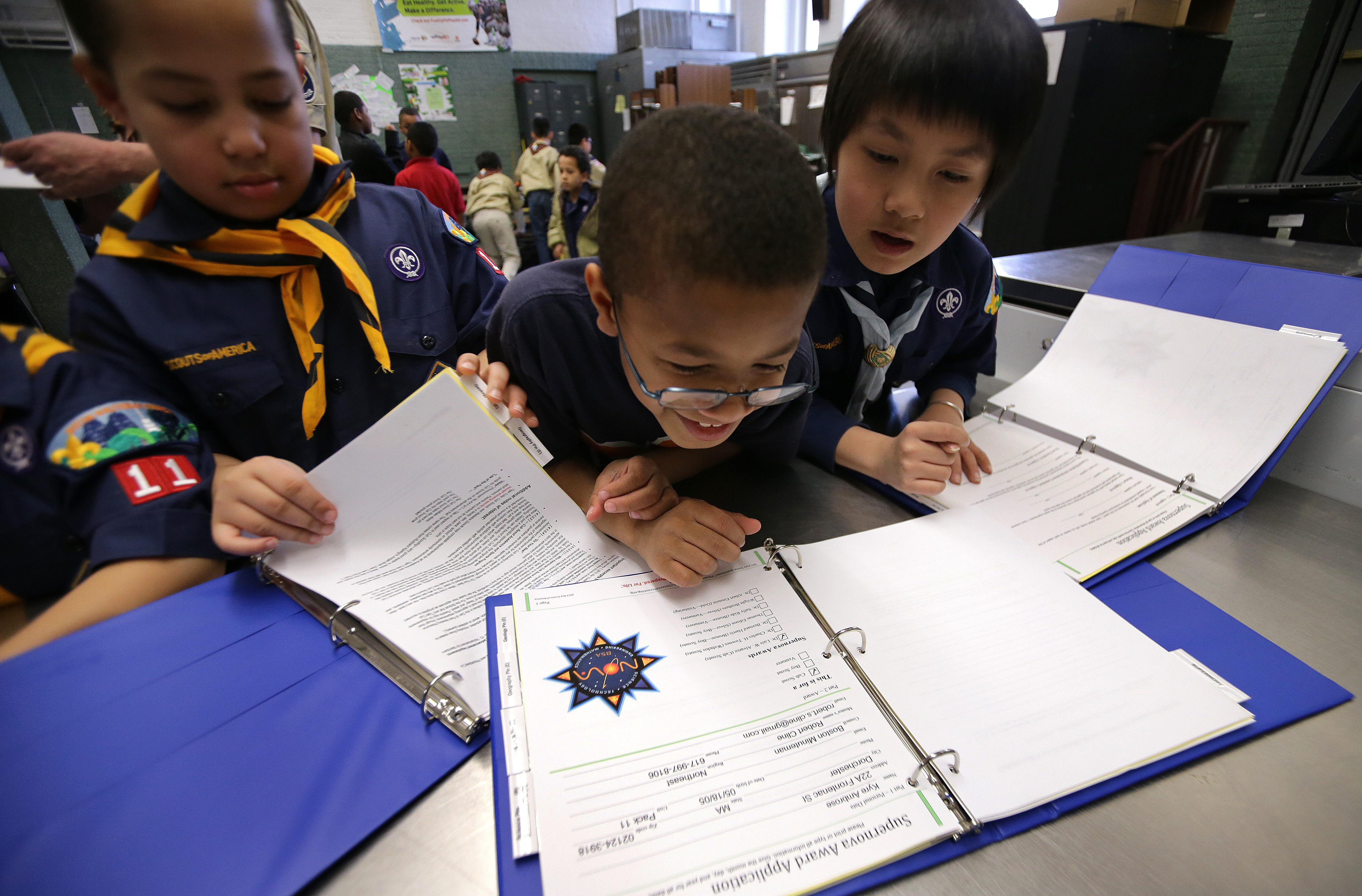 Isiah Pires (left), Kyre Ambrose, and Kerry Nguyen looked over documents together during their pack meeting.