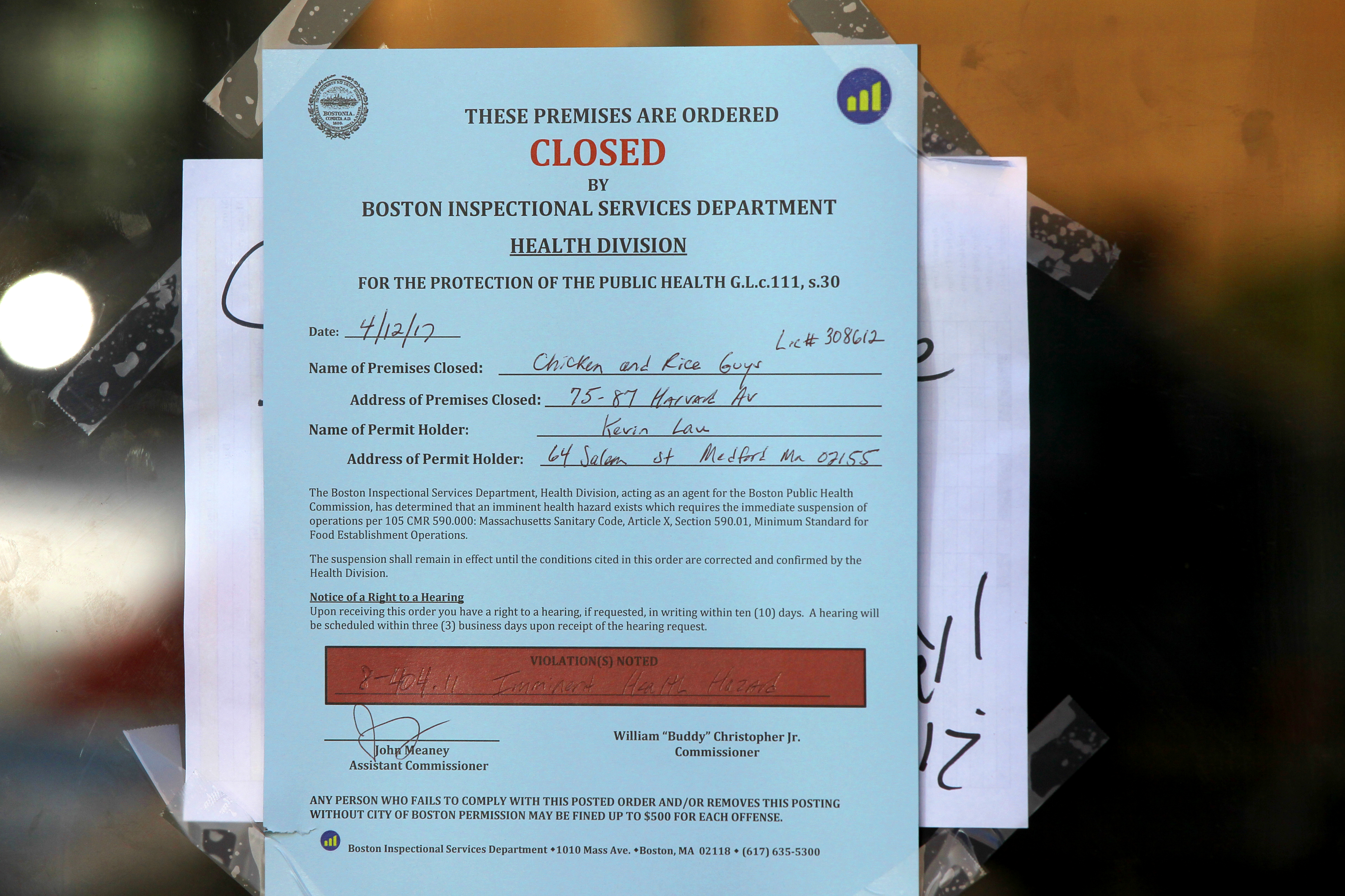 A closed sign in the window of Chicken & Rice Guys on Harvard Avenue.