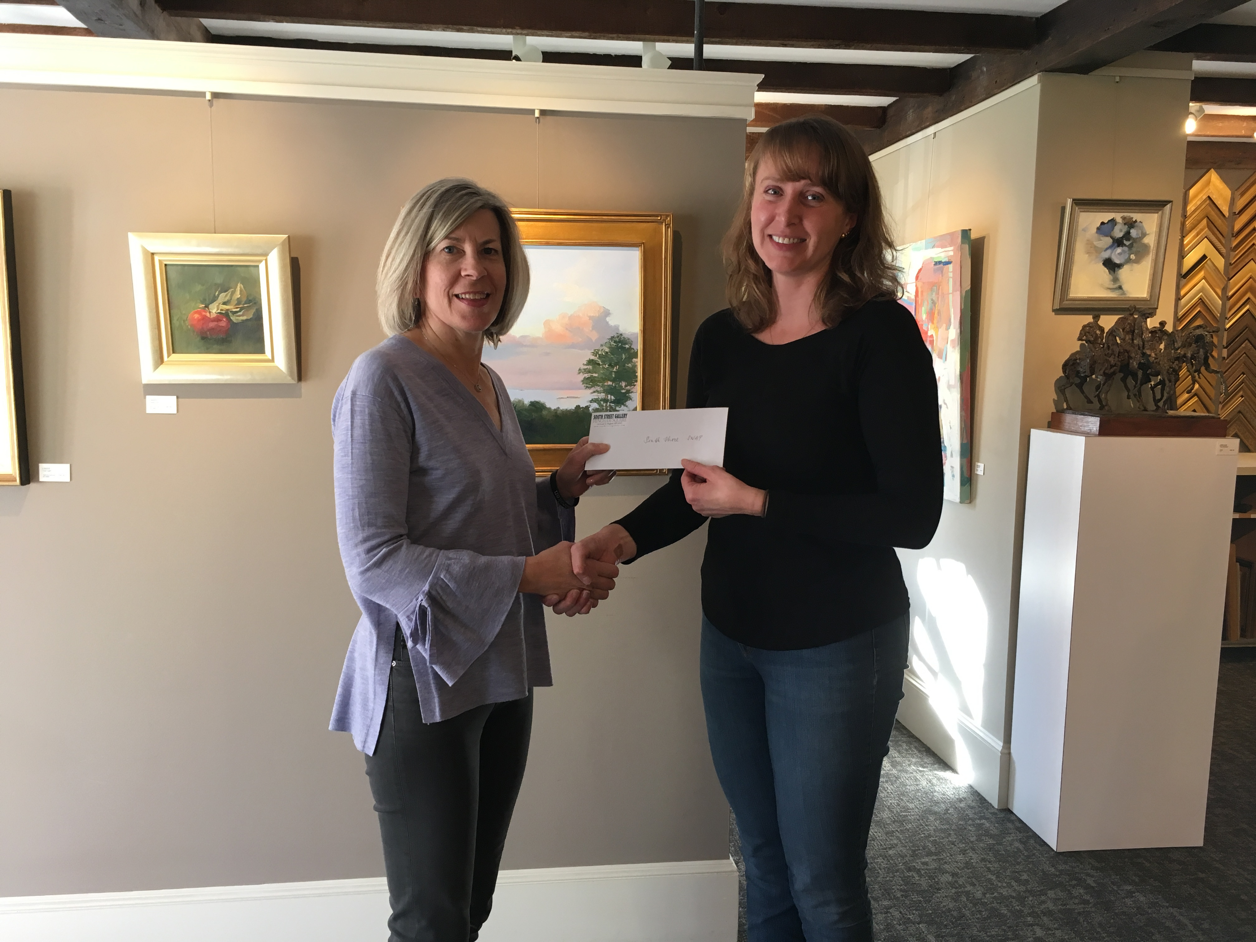 Donna Keaney, left, of the Special Needs Athletic Partnership, received a check from Kate Sotolova of South Street Gallery. The funds are raised through the gallery’s art appraisal days.