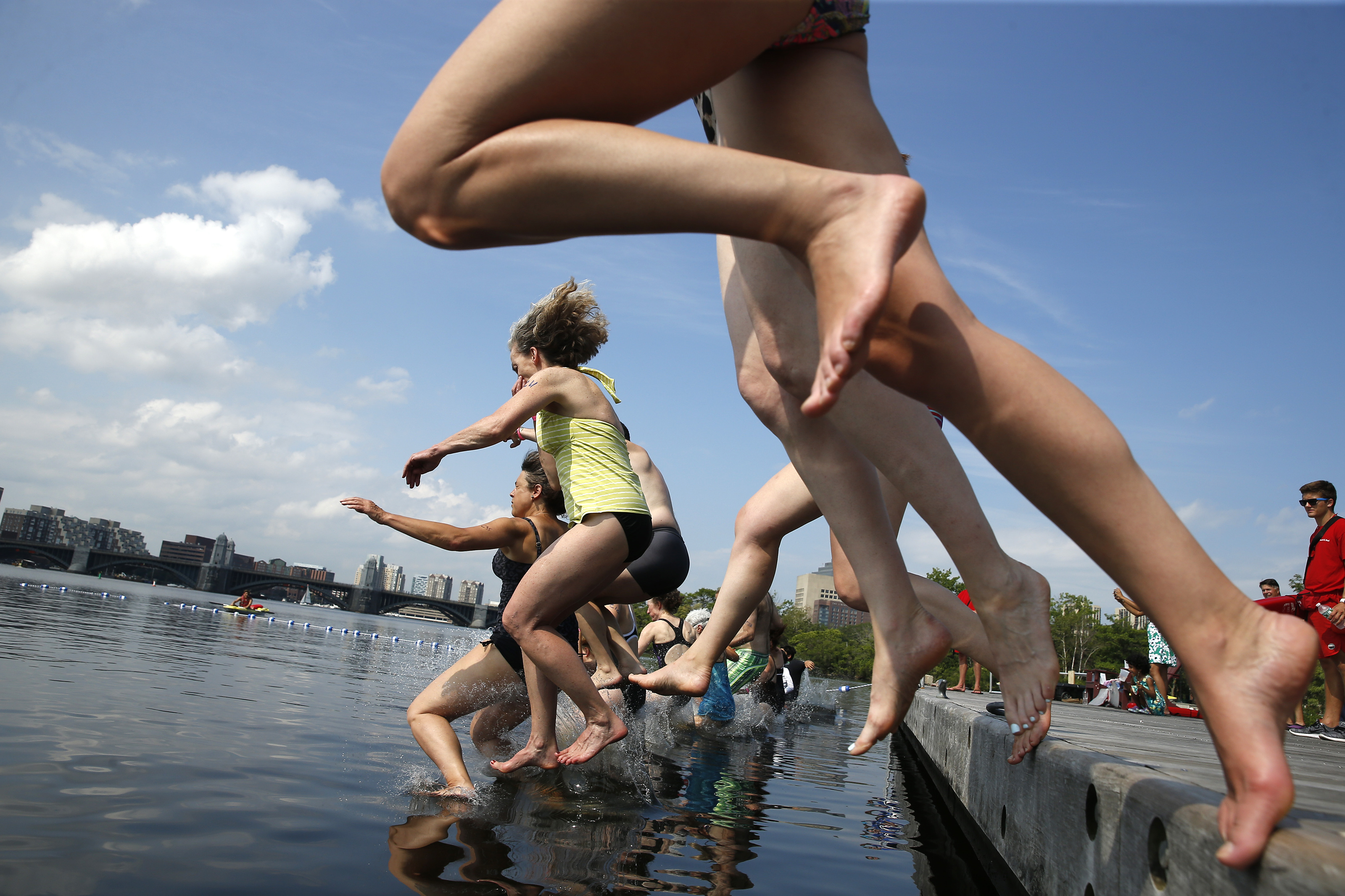 Swimmers jumped off of a dock during sanctioned swimming in the Charles River.