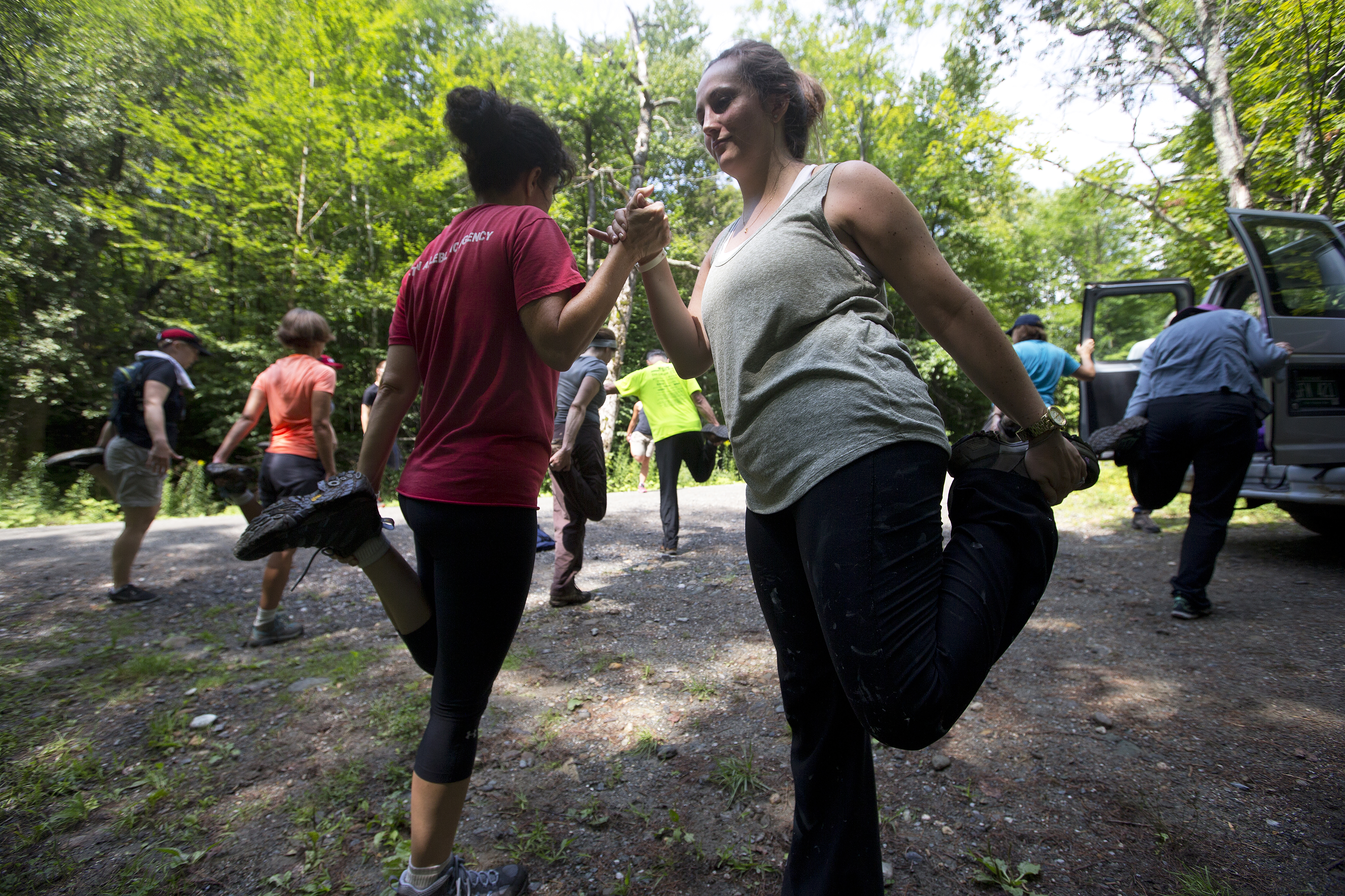 Hikers stretch their quads after a five-mile hike through the Vermont woods.
