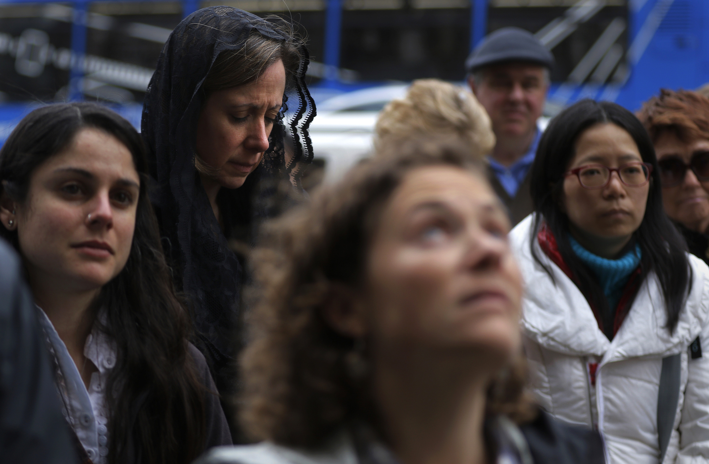 Silvia Gosnell (second from left) listened to the Rev. William Rich’s sermon during the “Stations of the City” Friday.
