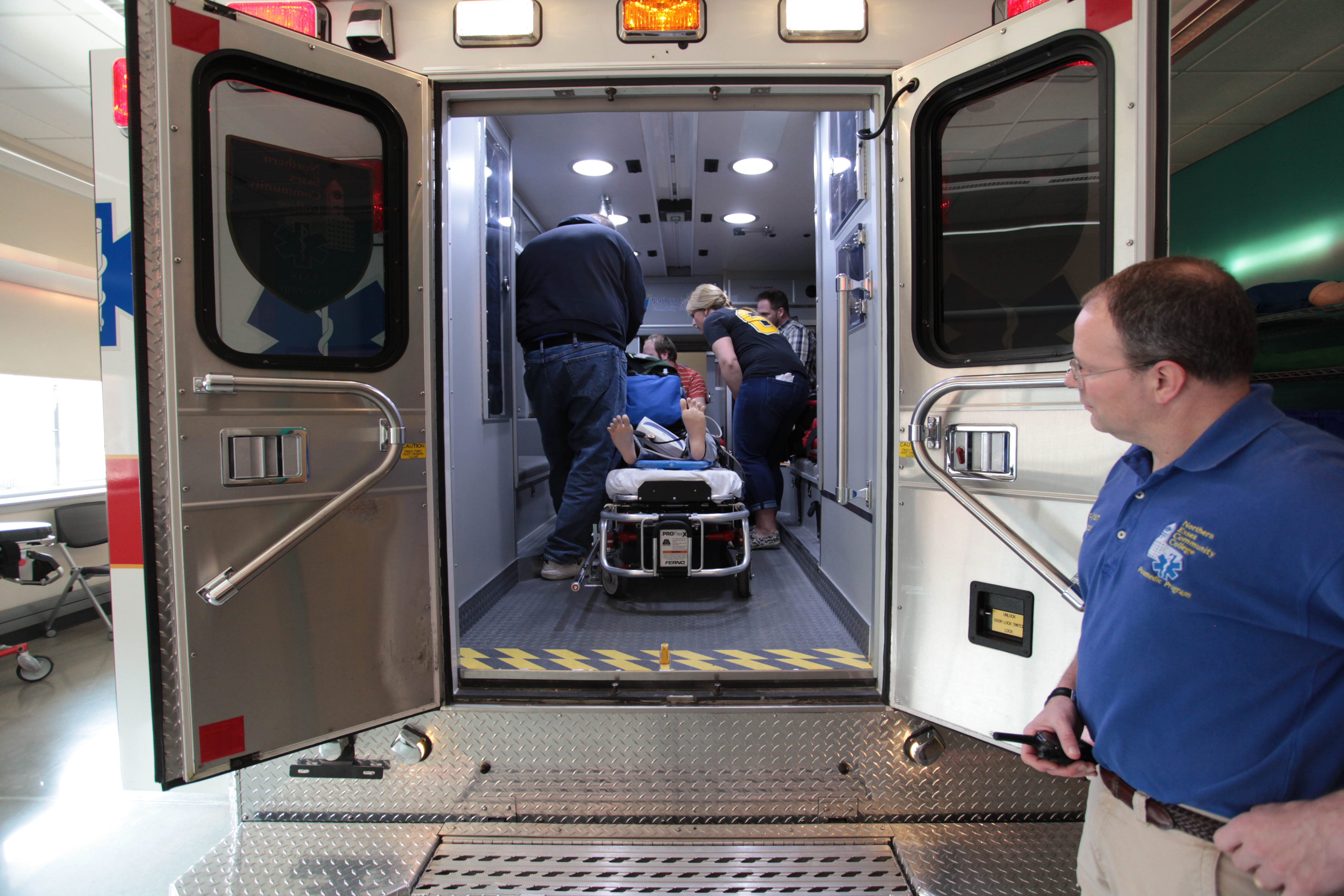 Rory Putnam, instructor for paramedics, watches as students work on mannequins at the El-Hefni Allied Health and Technology Center.