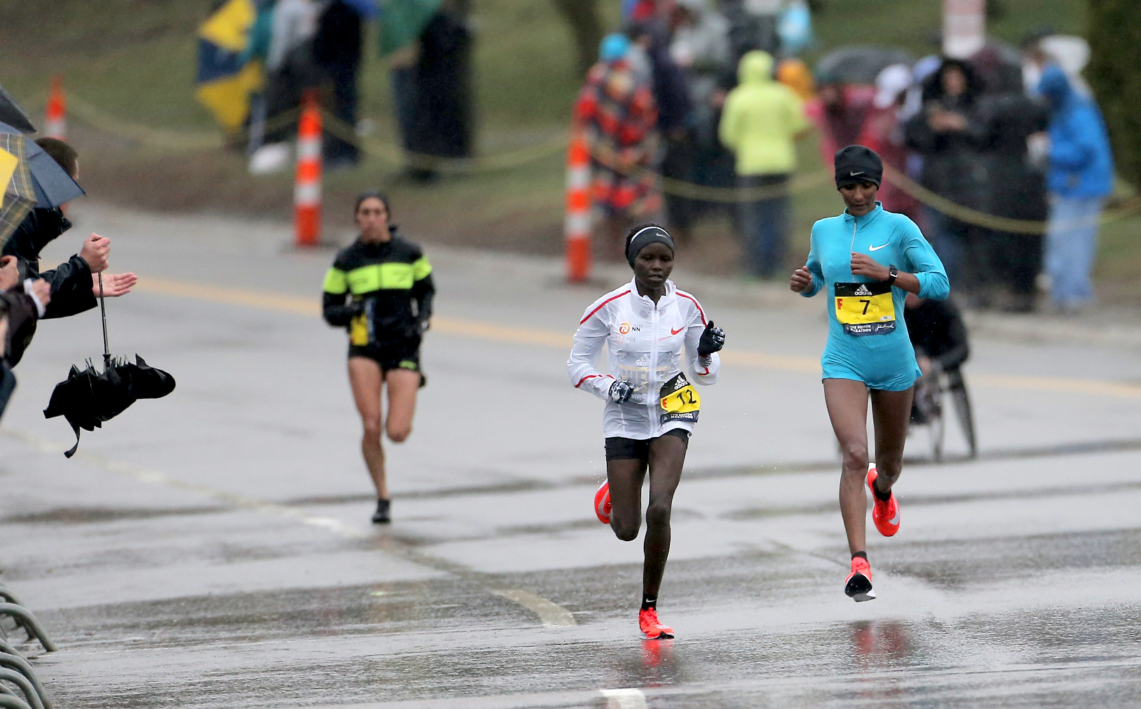 Linden (left) reels in Gladys Chesir (center) and Mamitu Daska (right) on Heartbreak Hill.