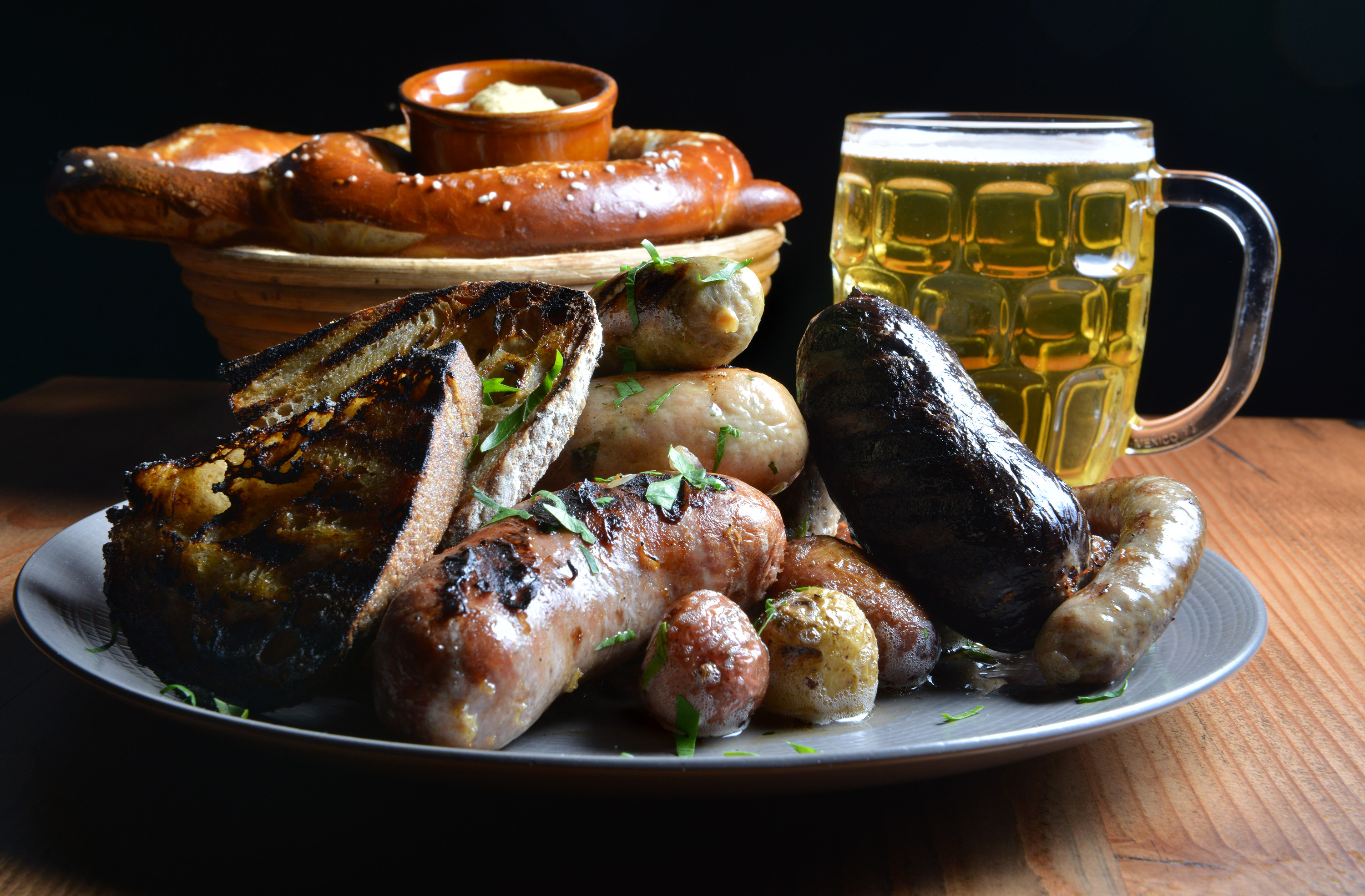 A Wurst Platter served with sauerkraut and potatoes with a Giant Haus Bretzel with roasted appel mustard and Weihenstephaner Dunkel Hefe-Weissbier at Bronwyn in Union Square.. Josh Reynolds for The Boston Globe (Lifestyle, First) 25dining