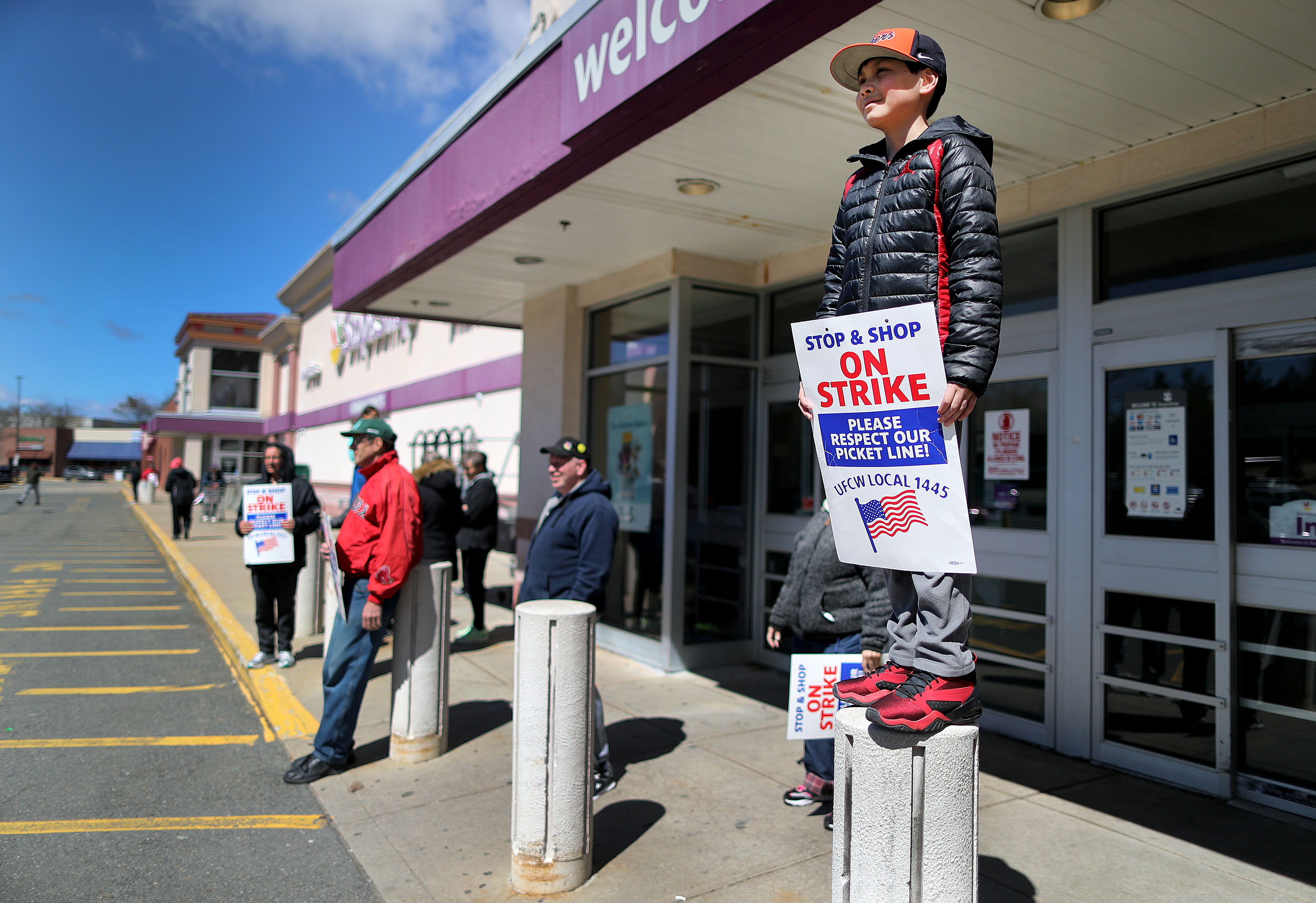 Nathan Ely, 11, stood on a column outside a Stop & Shop store in Watertown. His father, Christian Ely, is the produce manager there and has worked at Stop & Shop for 32 years. Ely is on school vacation this week.
