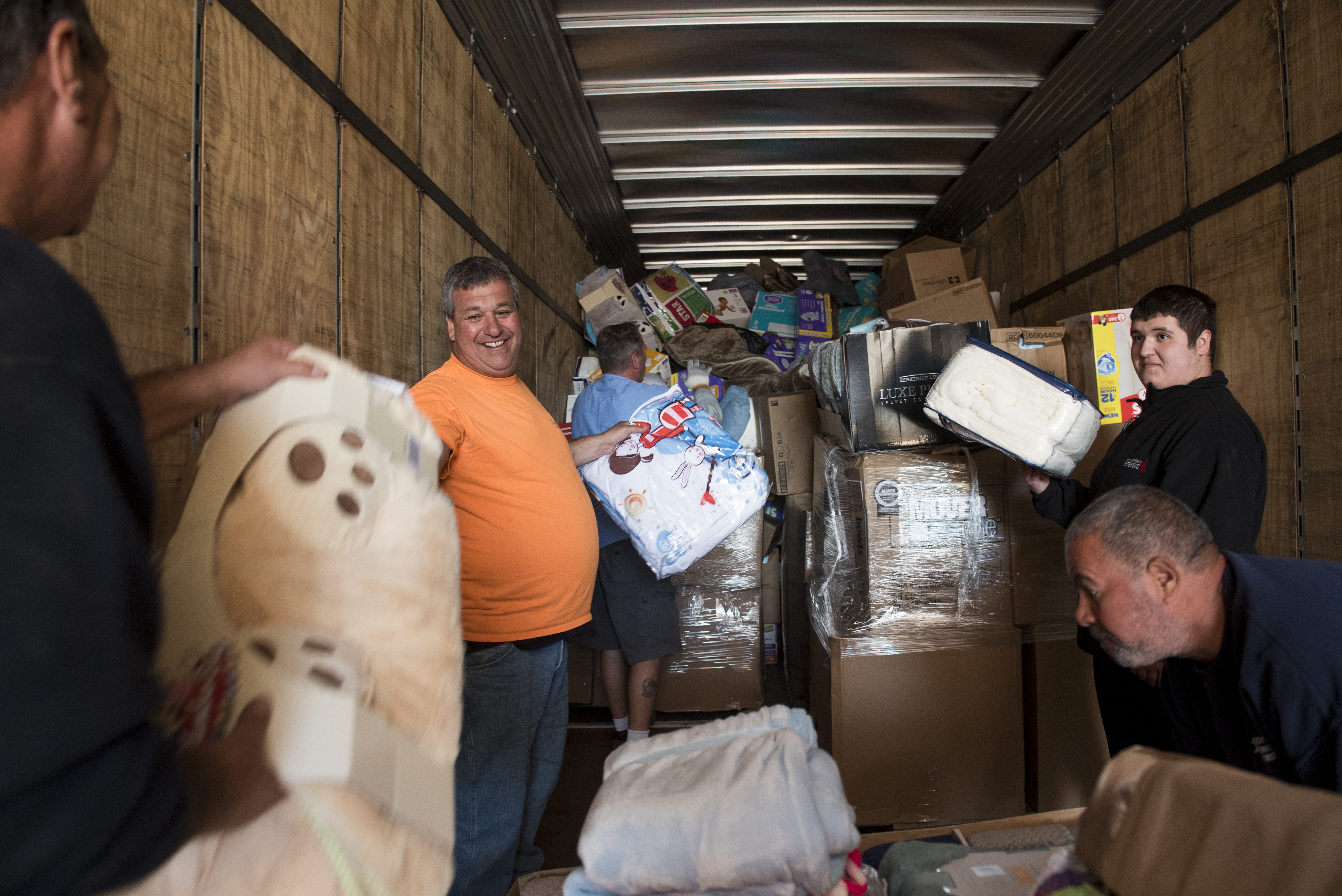 Kevin Velez of Lawton Welding (left) loaded his company's truck with the help of his son (far right) and volunteers from the Boston Housing Authority and Boston Public Works.