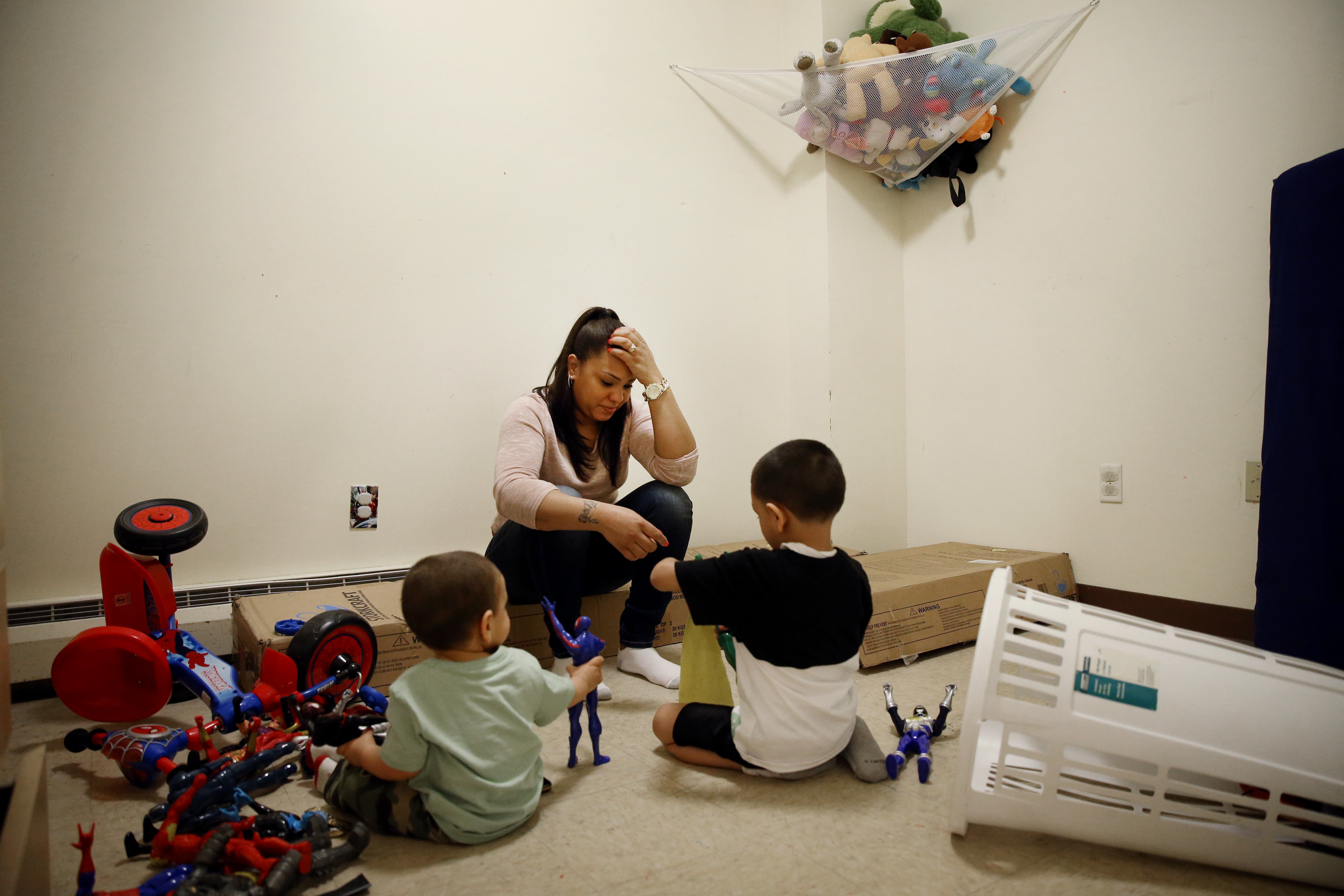 Lany Ruiz (center) sat with her children Joshua Ruiz, 18-months (left) and Alex, 5, while they played in the boys bedroom. Lany sat on the unassembled bunk beds she recently bought with her tax return.
