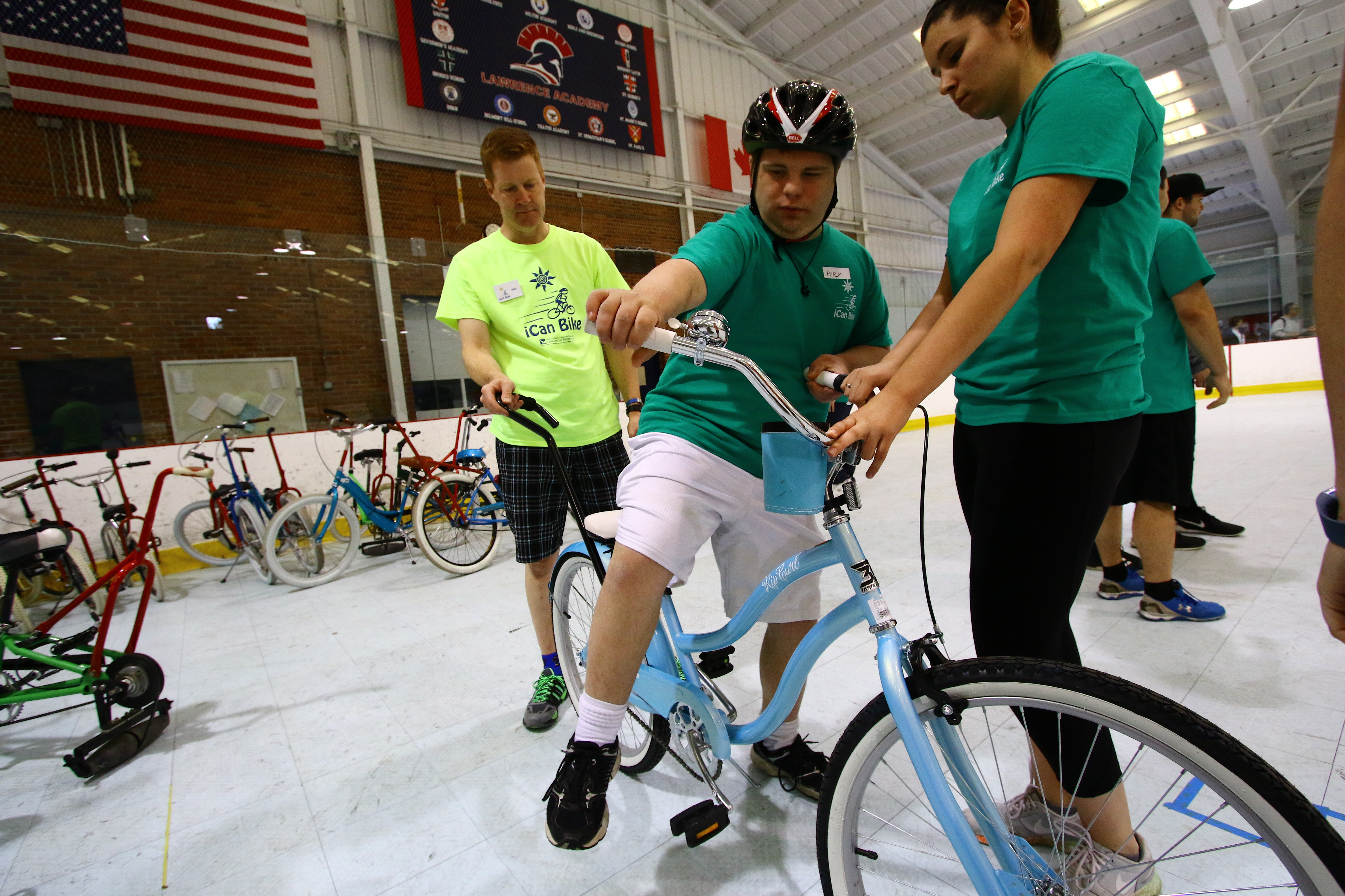 Ashley Michals, a UMass Lowell student, helped Alex Fee, 21, of Chelmsford onto his bike.