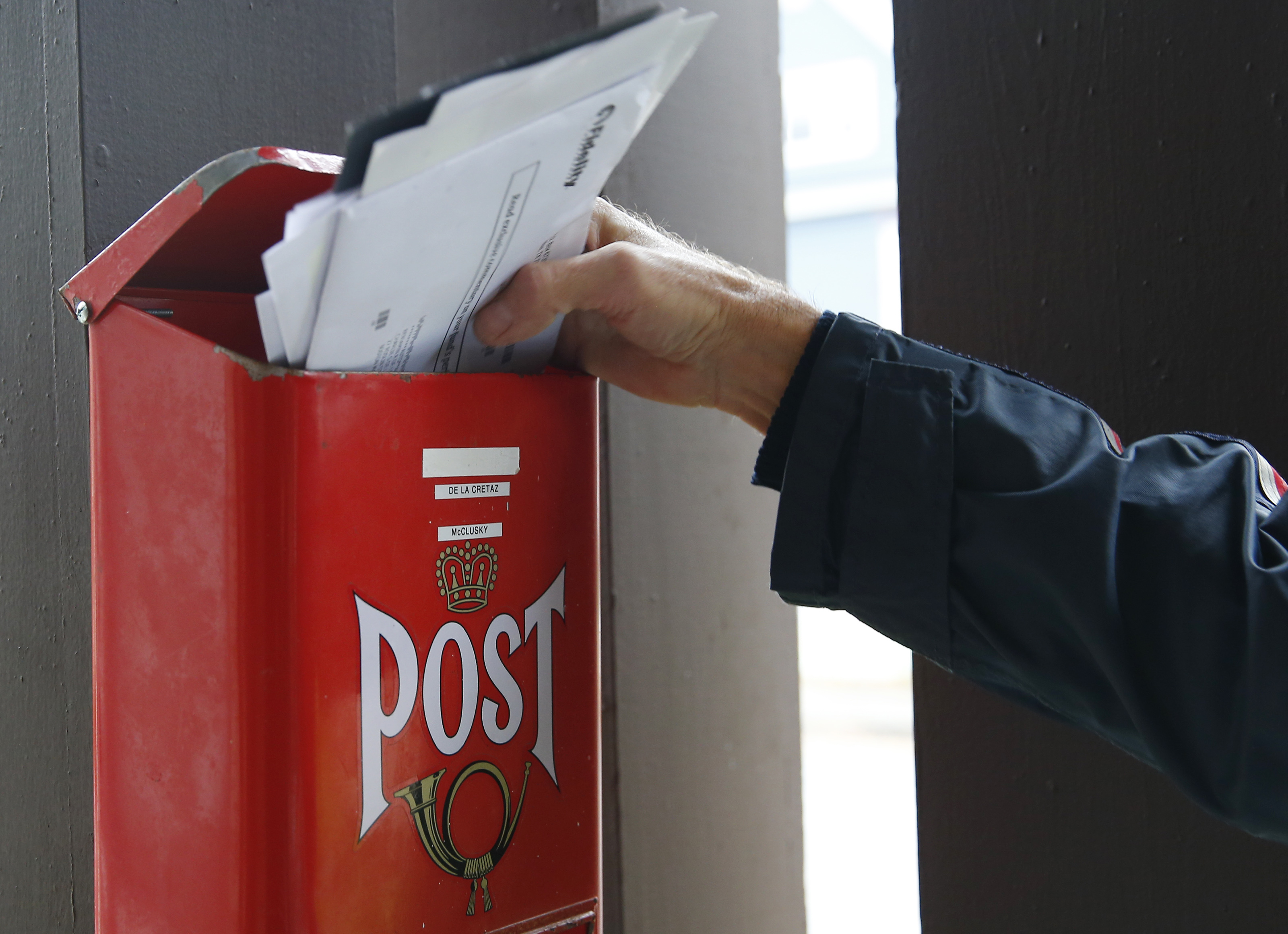 Newayno stuffed letters into a mailbox on his route.