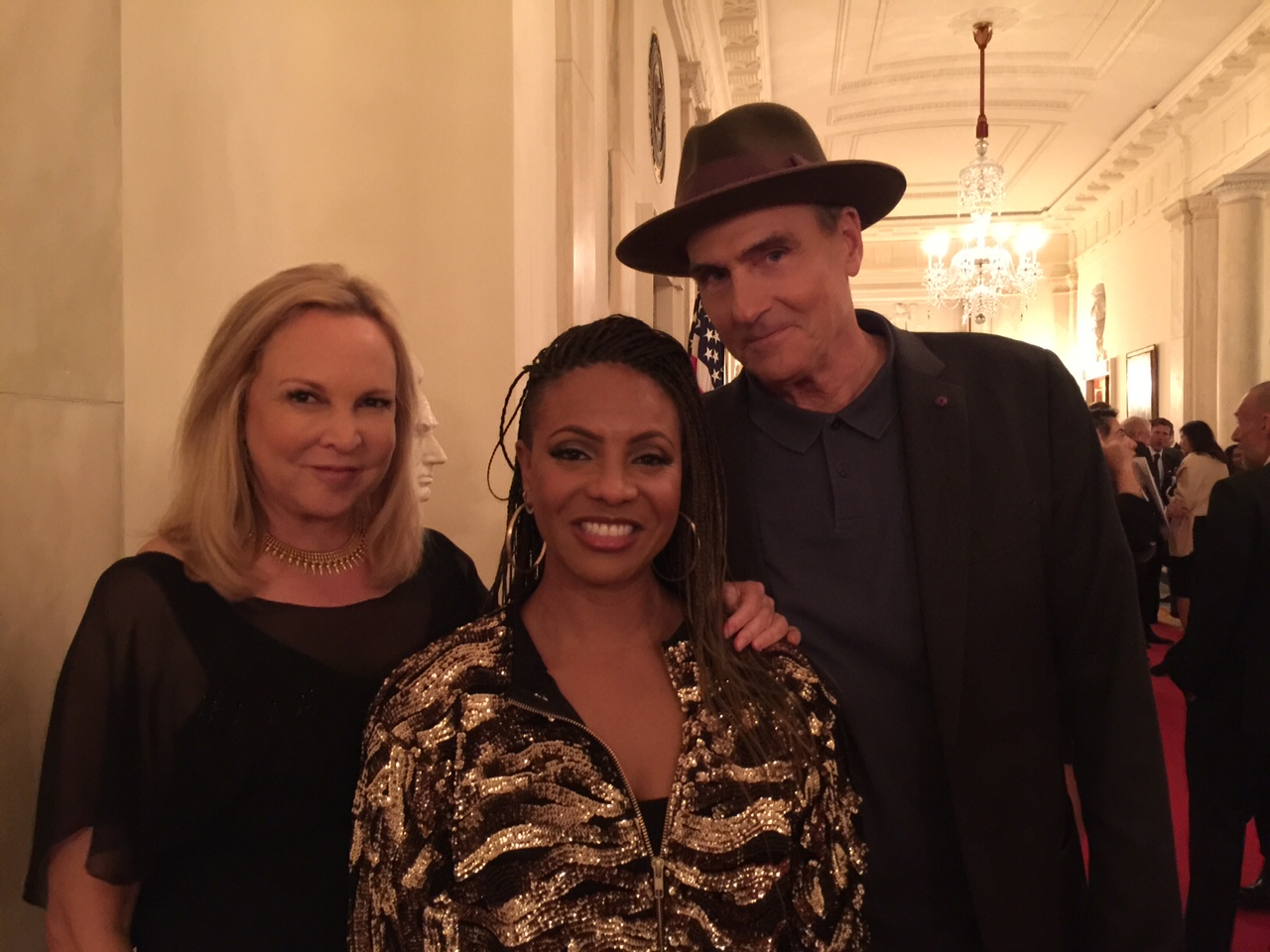 Rapper MC Lyte flanked by Kim and James Taylor at the White House.