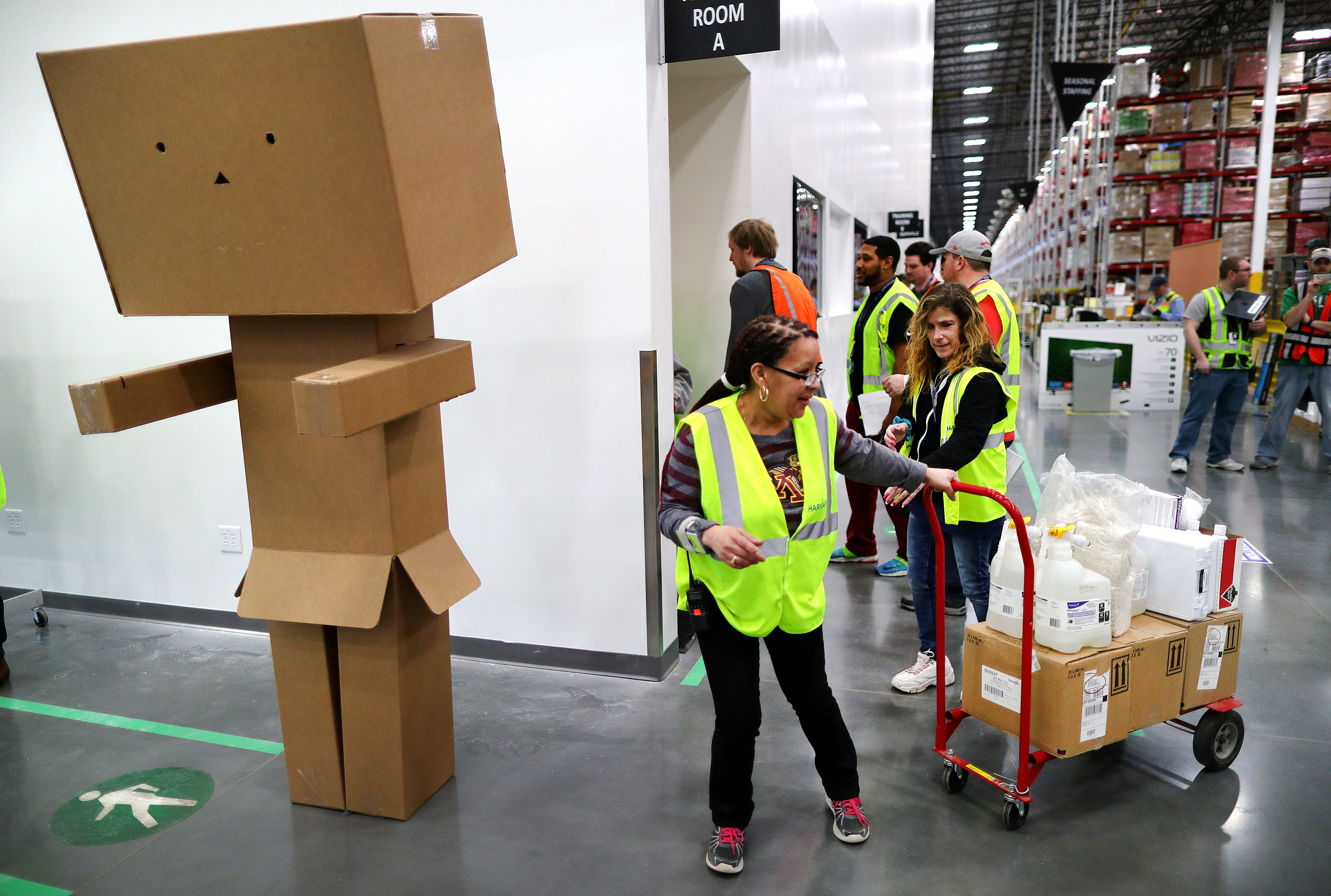 Workers pass by "packie," a box sculpture near the entrance to the warehouse.
