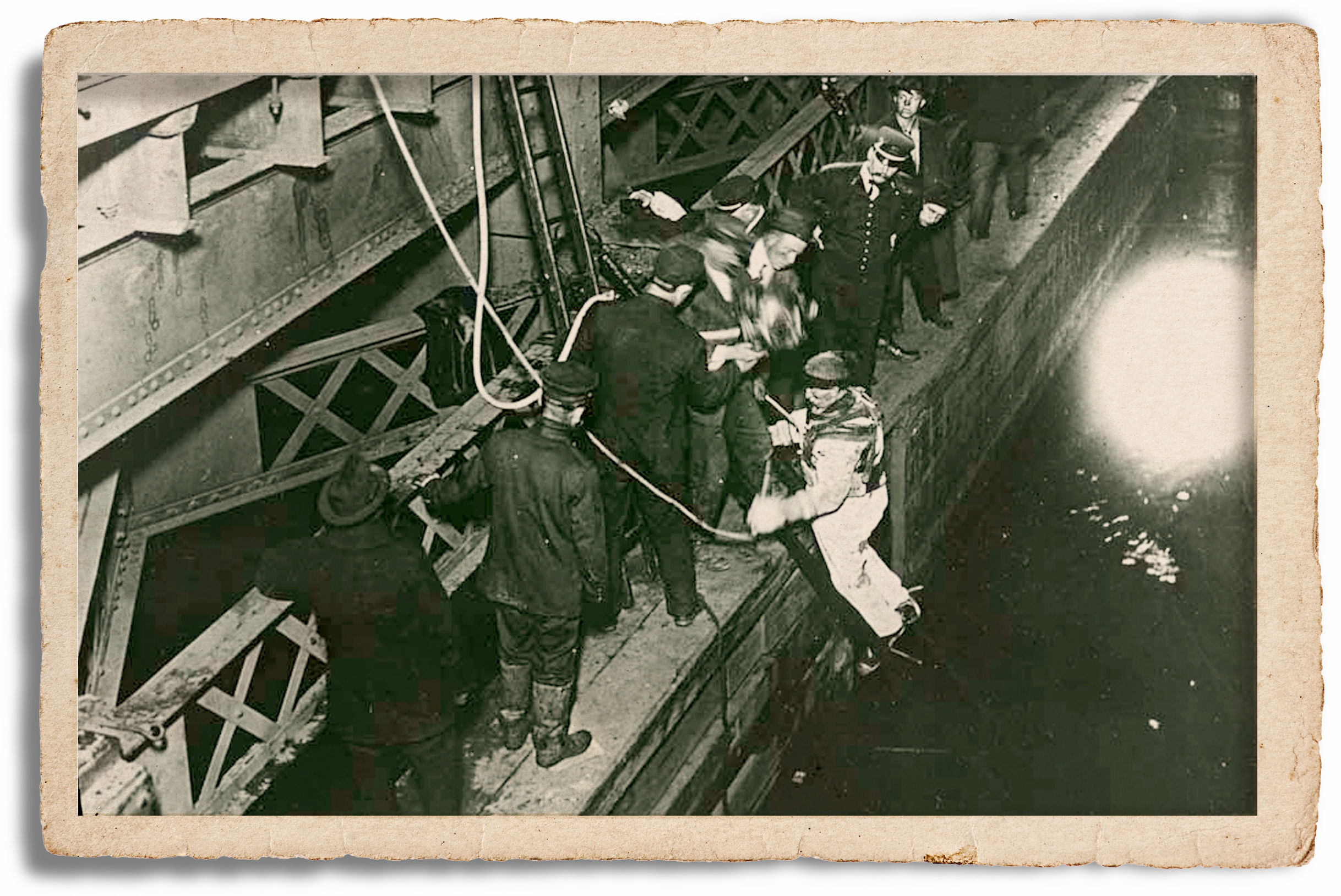 Peter Foley prepares to dive underneath the bridge on the night of the accident. Diving in those days was a matter of teamwork, with a heavy suit and helmet, weighted shoes, and lines connecting the diver to handlers on the surface. Foley was the first to discover that the streetcar was lying in the muck right side up, and he saw the bodies of many victims protruding from broken windows.
