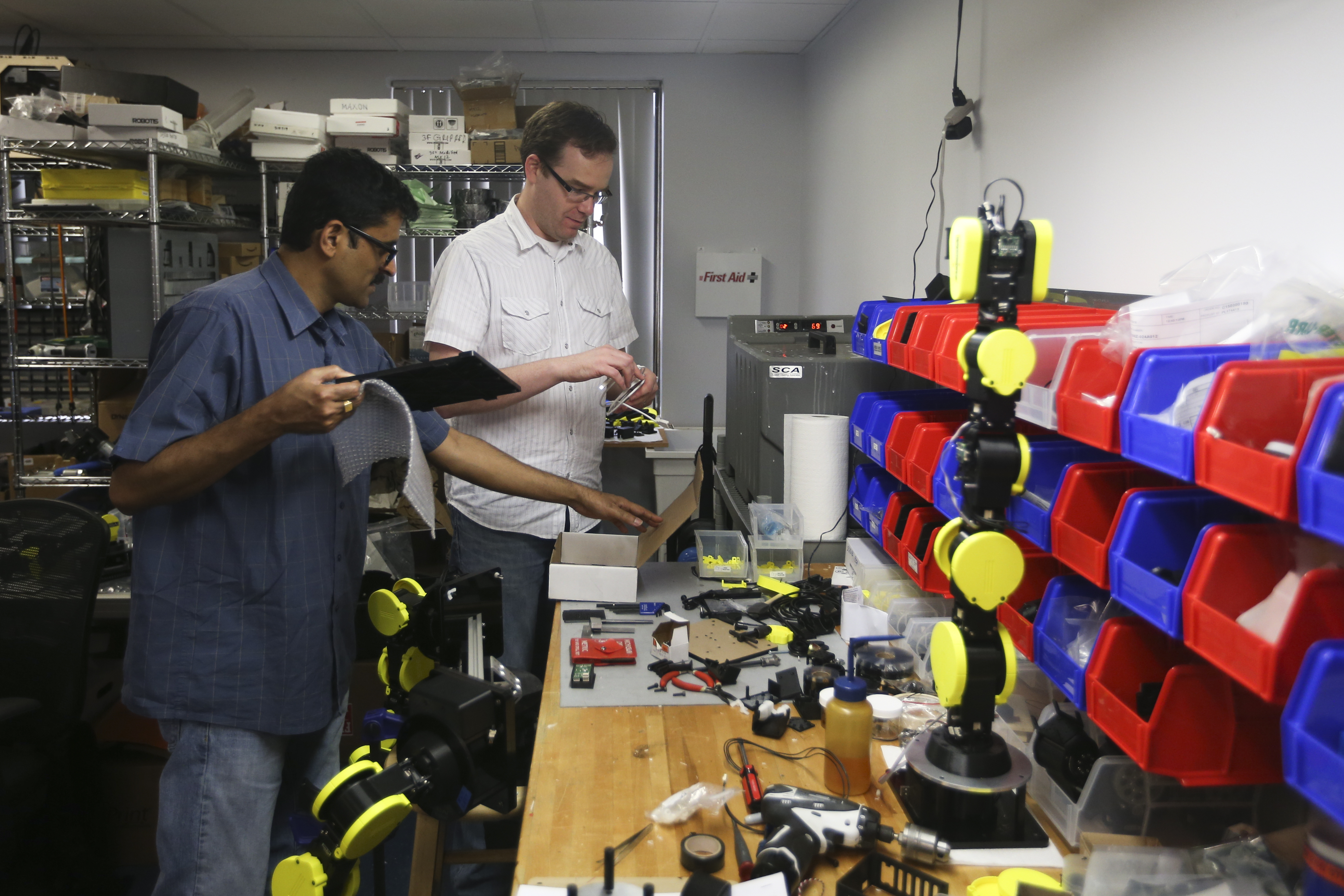 Murphy (left) and Ranjan Mishra organized parts at Energid Technologies in Burlington.