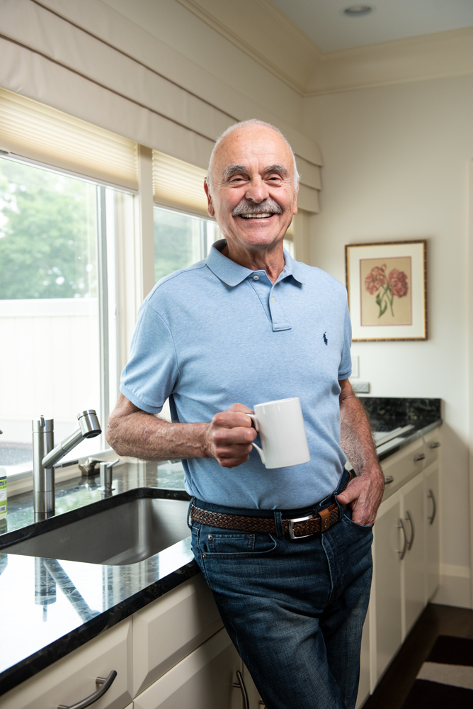 Lou Pandolfe in his kitchen, delighted to hold a cup steady again after undergoing a noninvasive focused ultrasound procedure at Brigham and Women's Hospital.