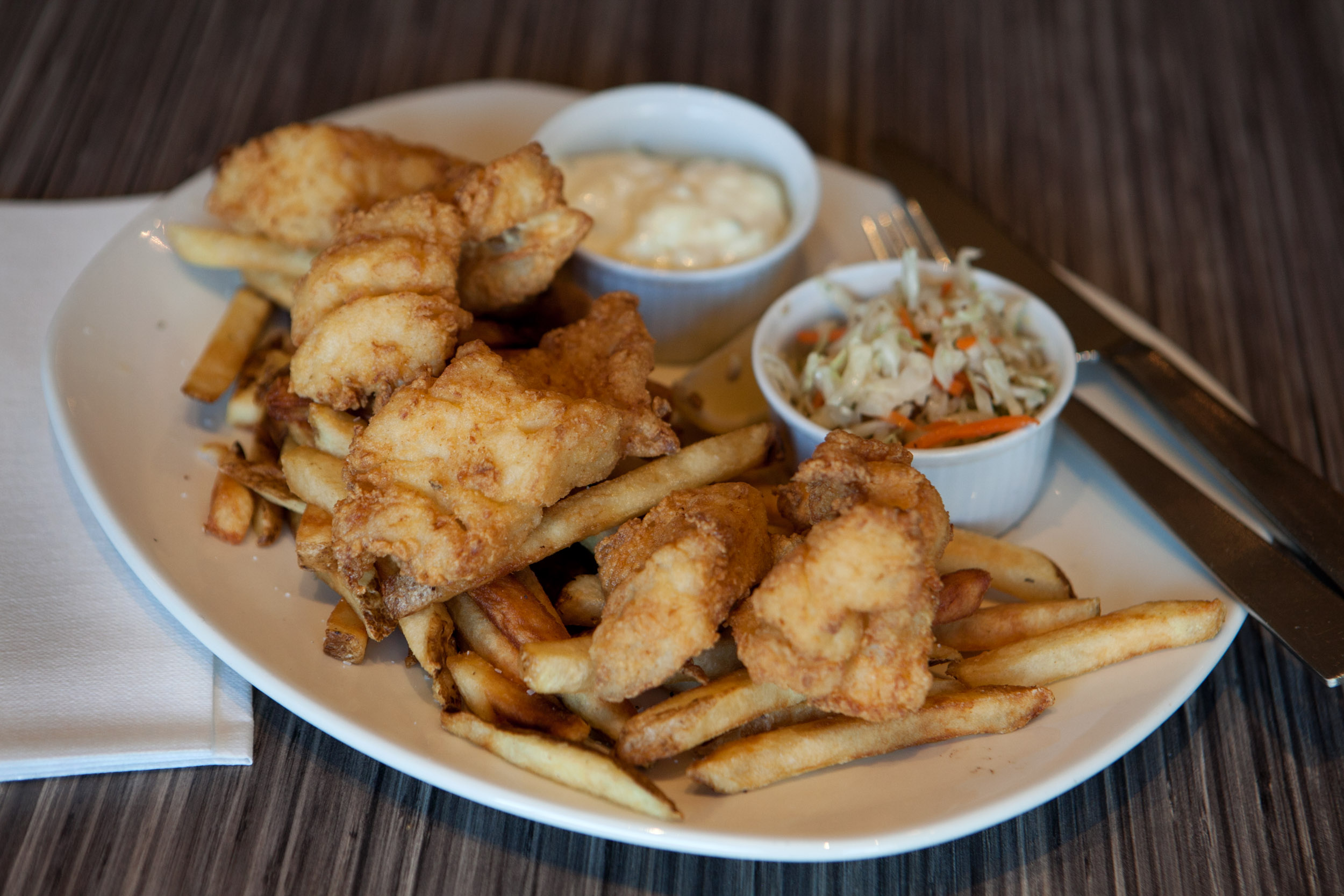 Fish and chips with cole slaw and tartar sauce.