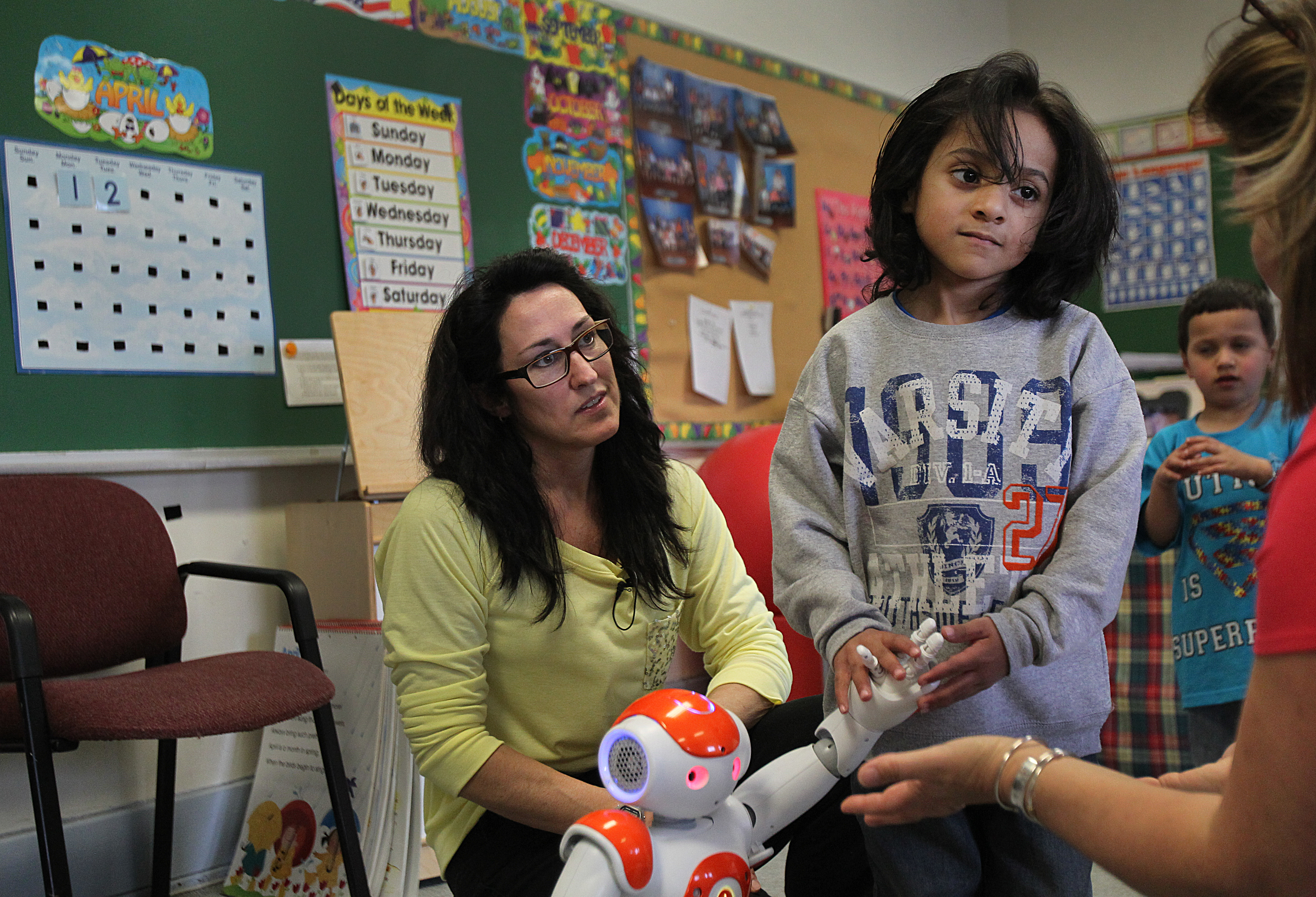 Jadiel Vargas, with teacher Bernadette Roy, held a robot’s hand during one display.