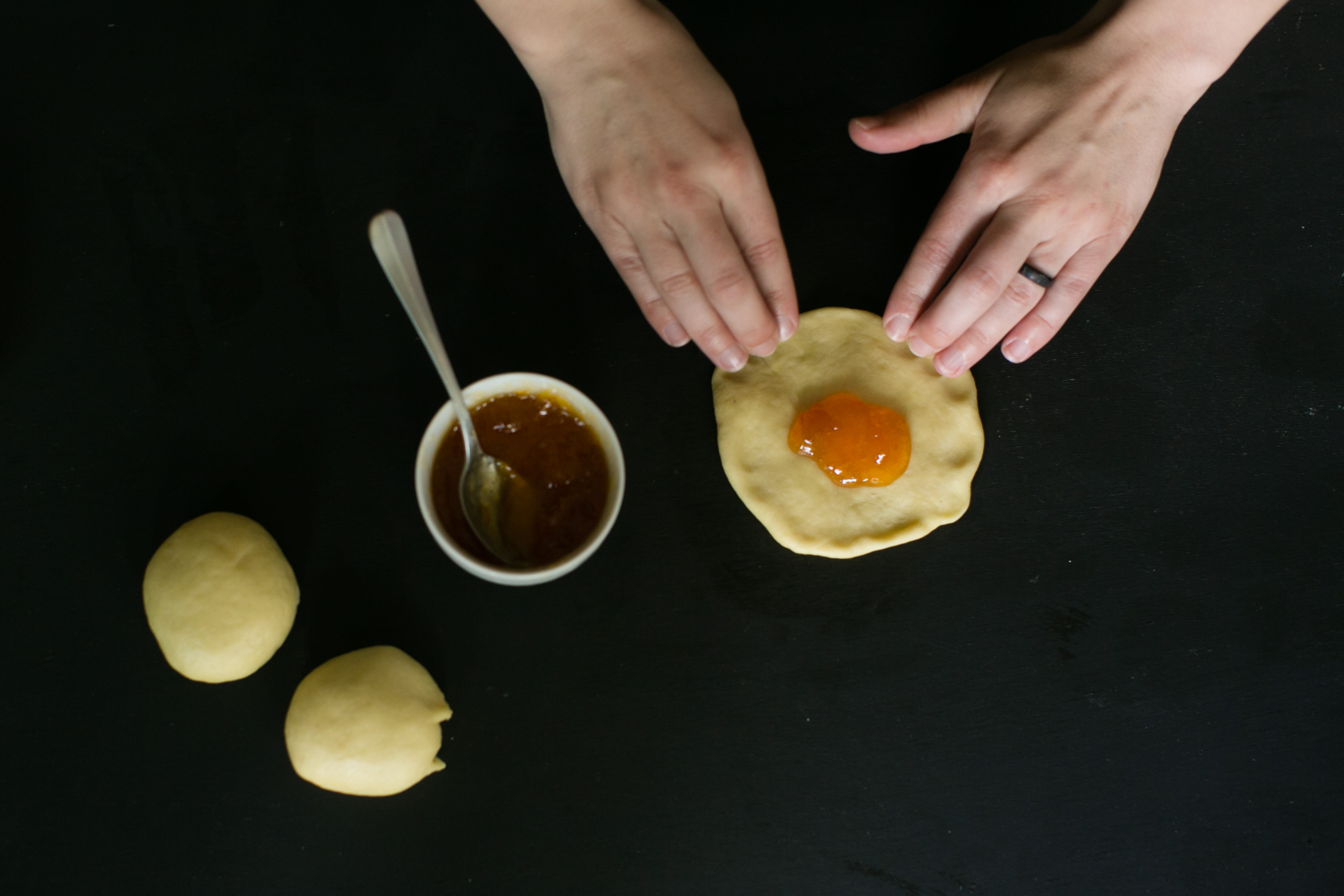 The ball is flattened into a circle, and apricot jam is placed at the center.