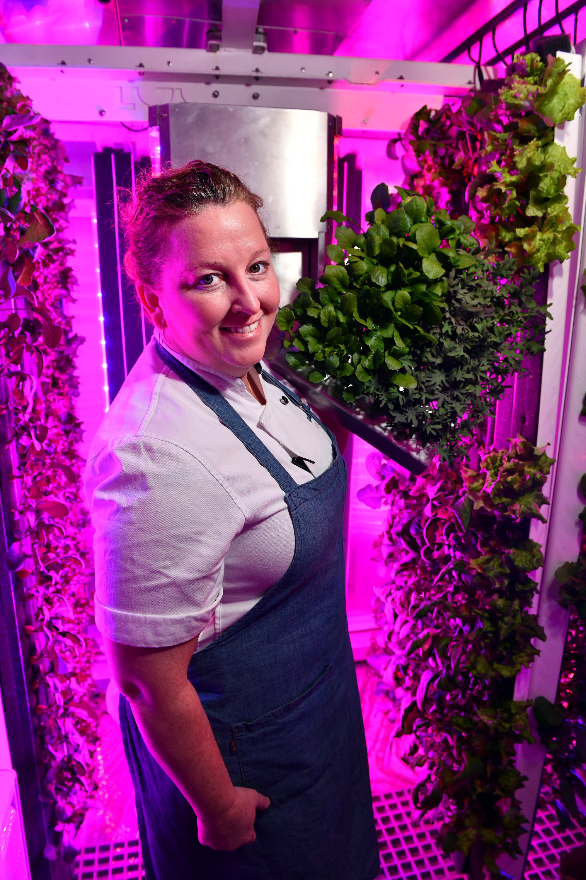Chef-owner Mary Dumont with broccoli rabe and mizuna grown in the on-site hydroponic garden inside a modified shipping container.