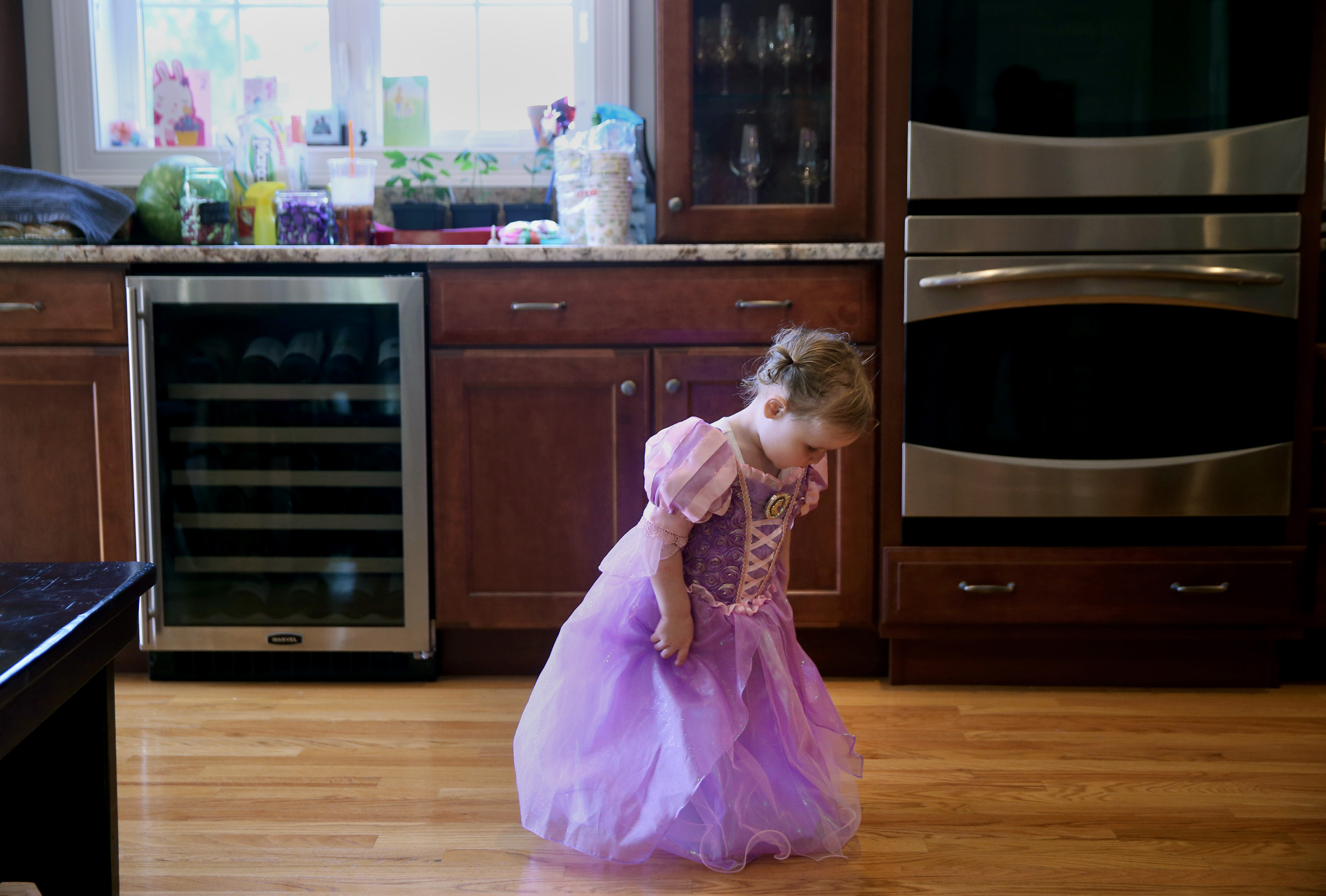 Emma Genest looks at her Rapunzel dress before her birthday party.