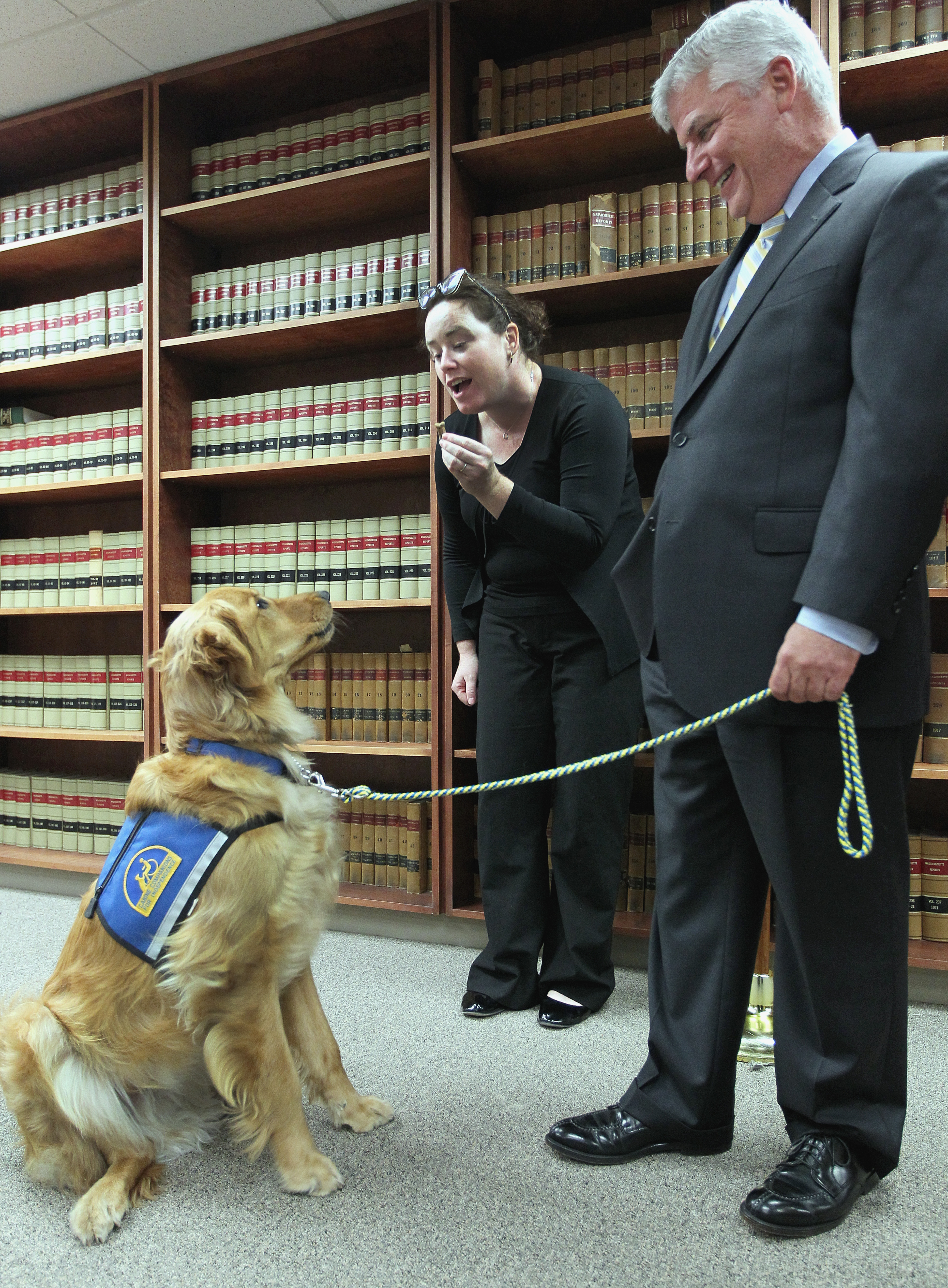 Suffolk County District Attorney Daniel F. Conley looked on as handler Kara Hayes gave a treat to Indy.