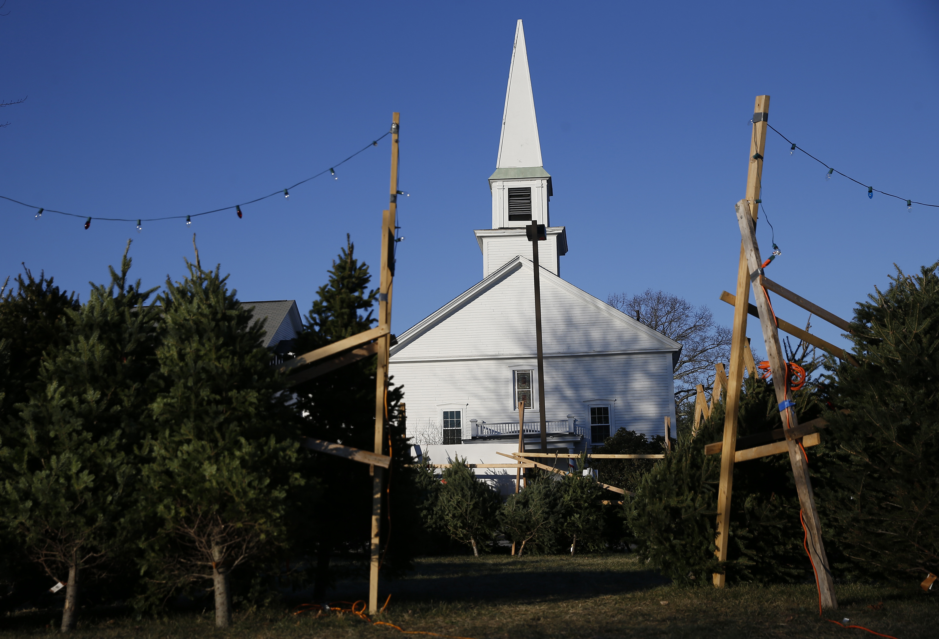 Christmas trees are for sale in front of the United Church of Christ, Congregational in Boxborough.