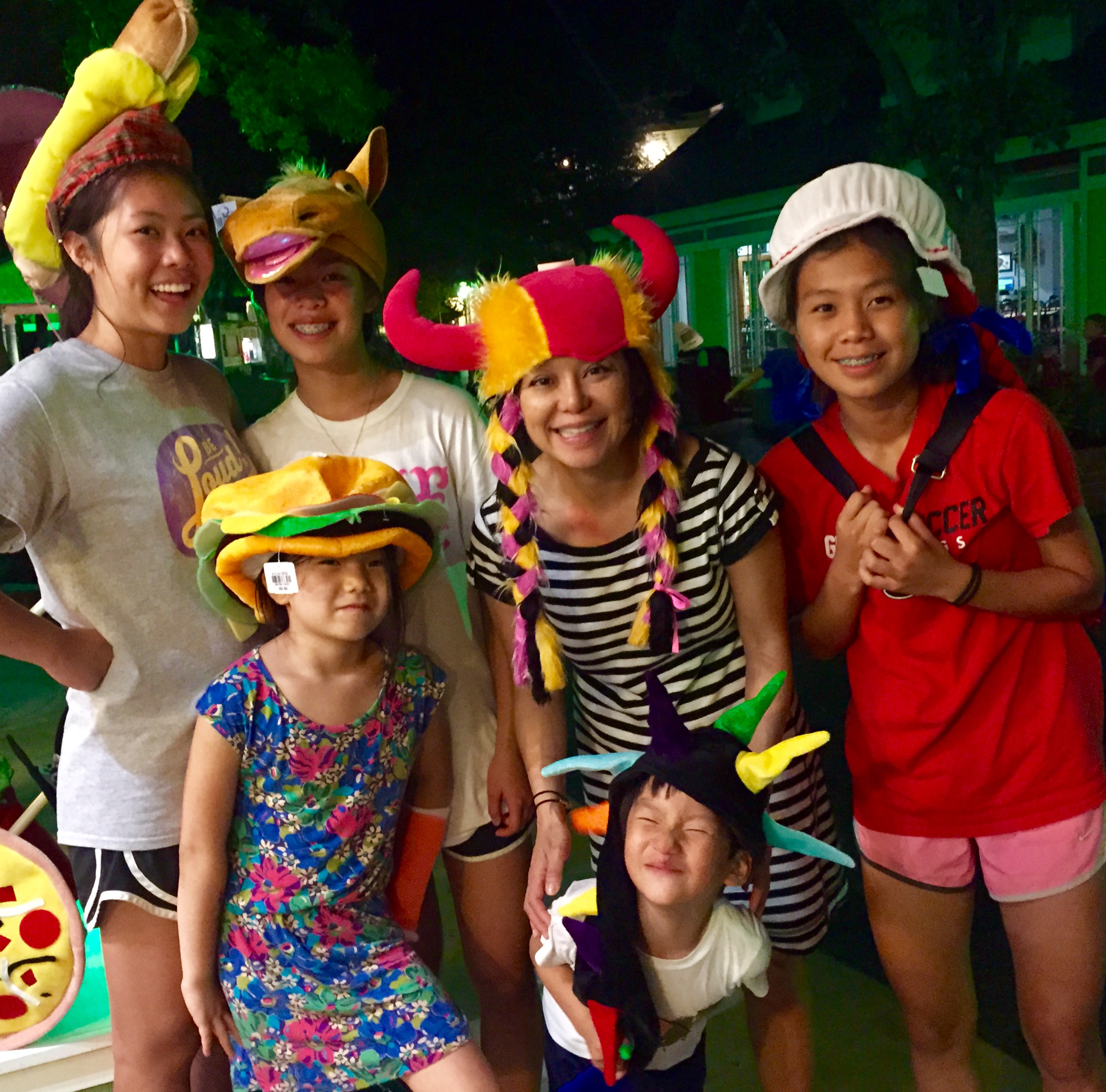 The author, Janet Wu, and her nieces and a nephew check out some wild and crazy hat-stall offerings at Dollywood.