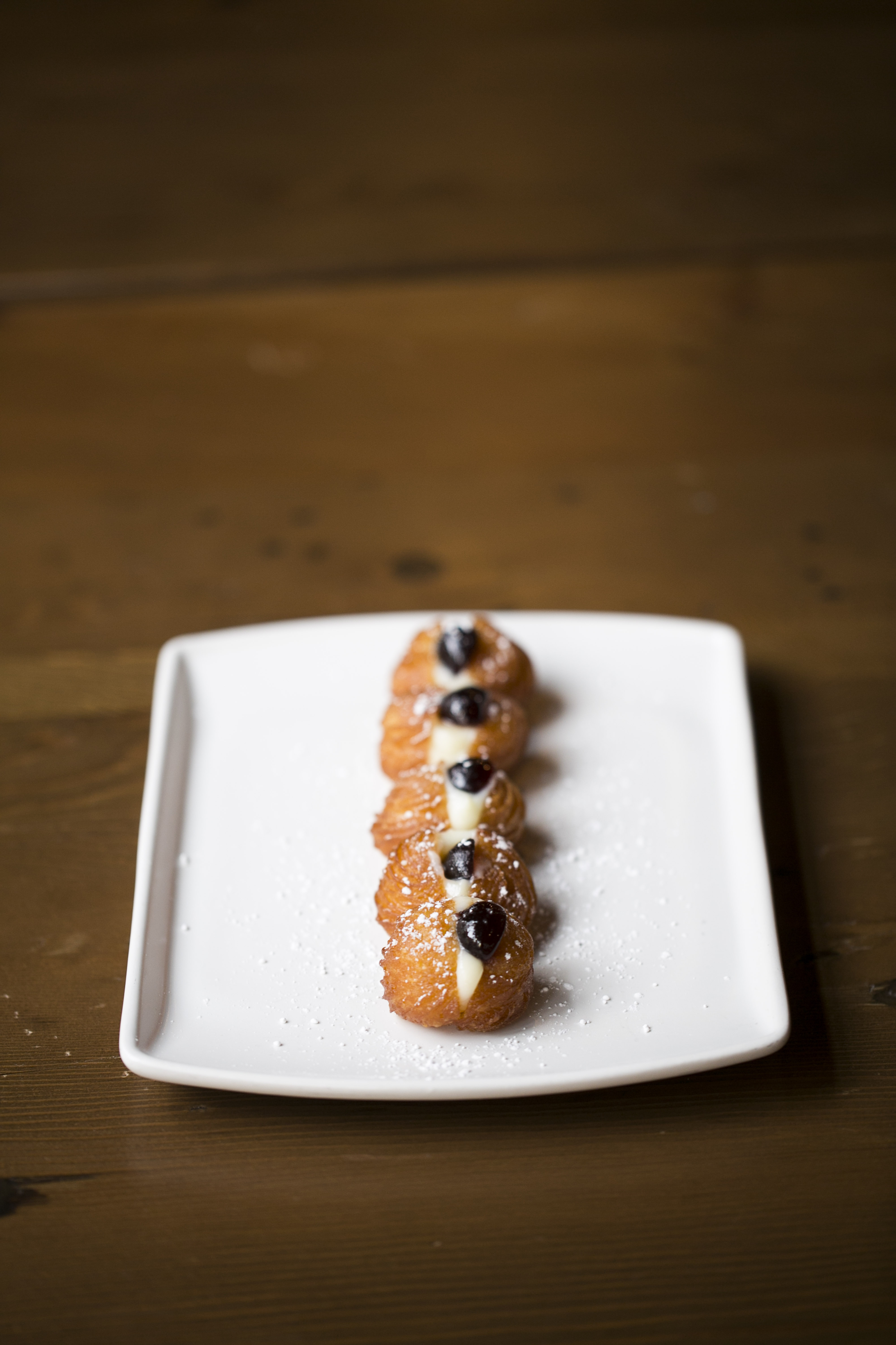 Bocconcini are sweet fritters filled with cream and dotted with Amarena cherries.