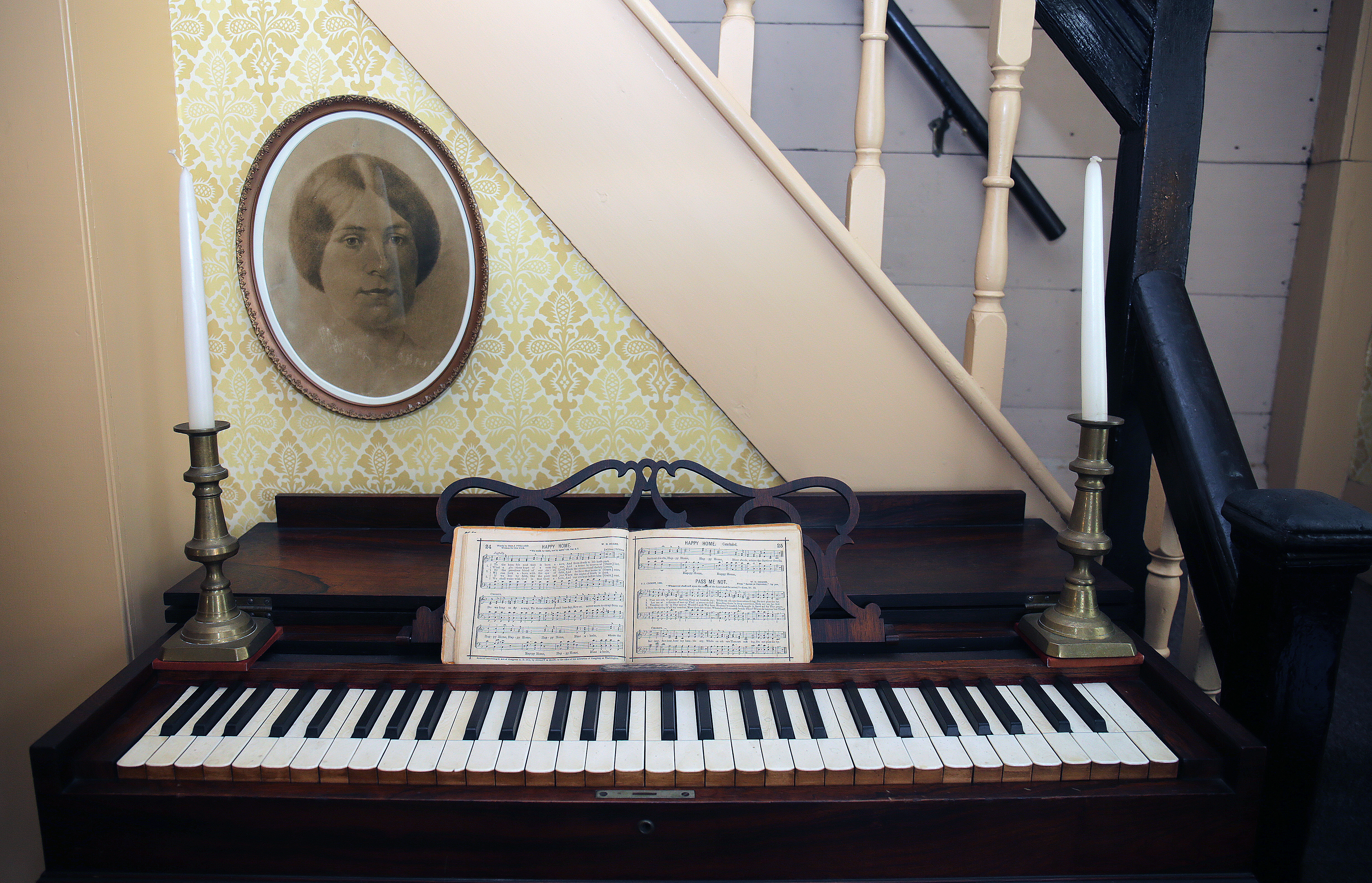 Elizabeth Alcott’s portrait hangs above the melodian she played inside Orchard House. Quiet and shy, she was portrayed as Beth in “Little Women.”