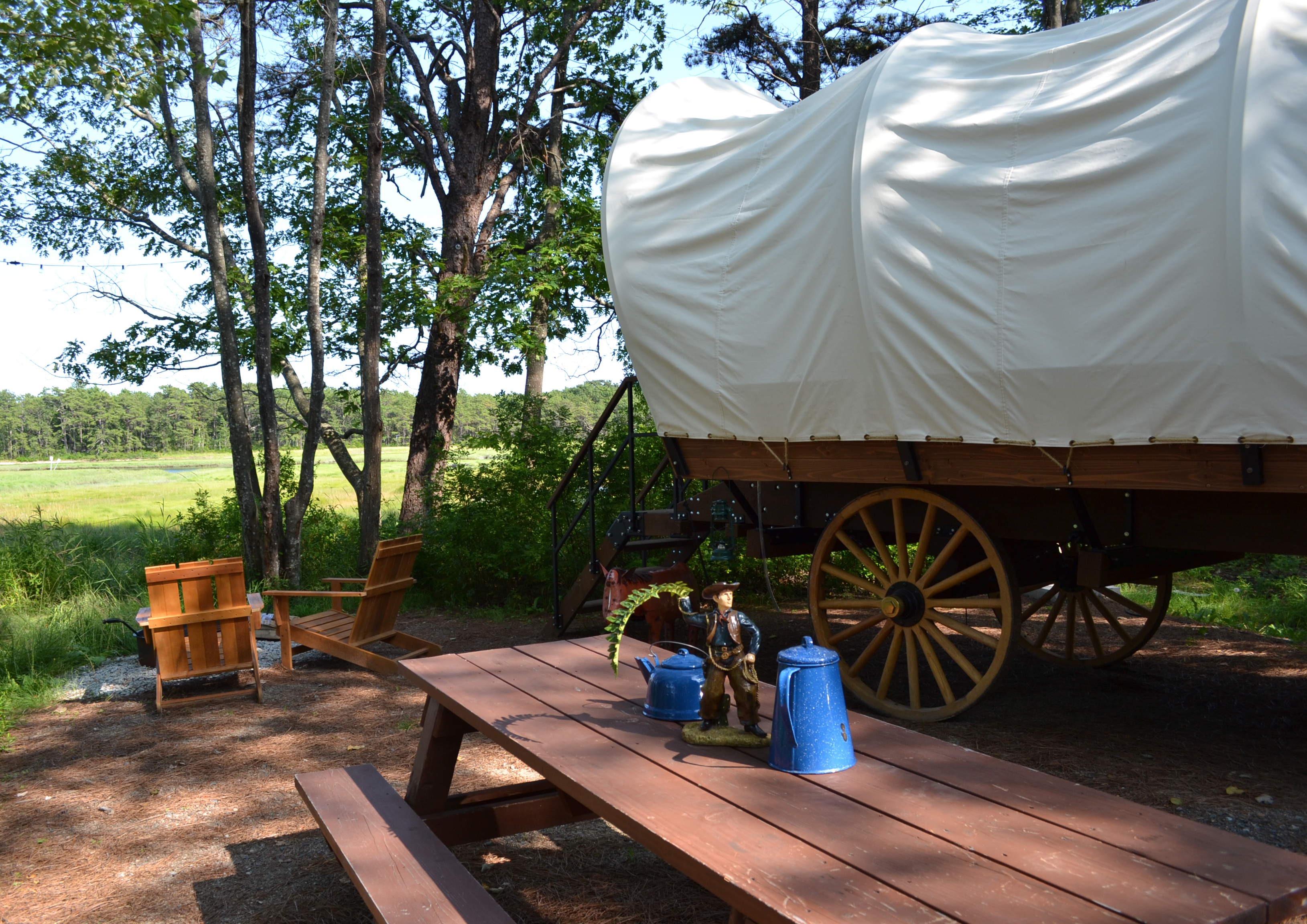 At Sandy Pines Campground, you can stay in one of their Unique Retreats, like a Conestoga wagon.