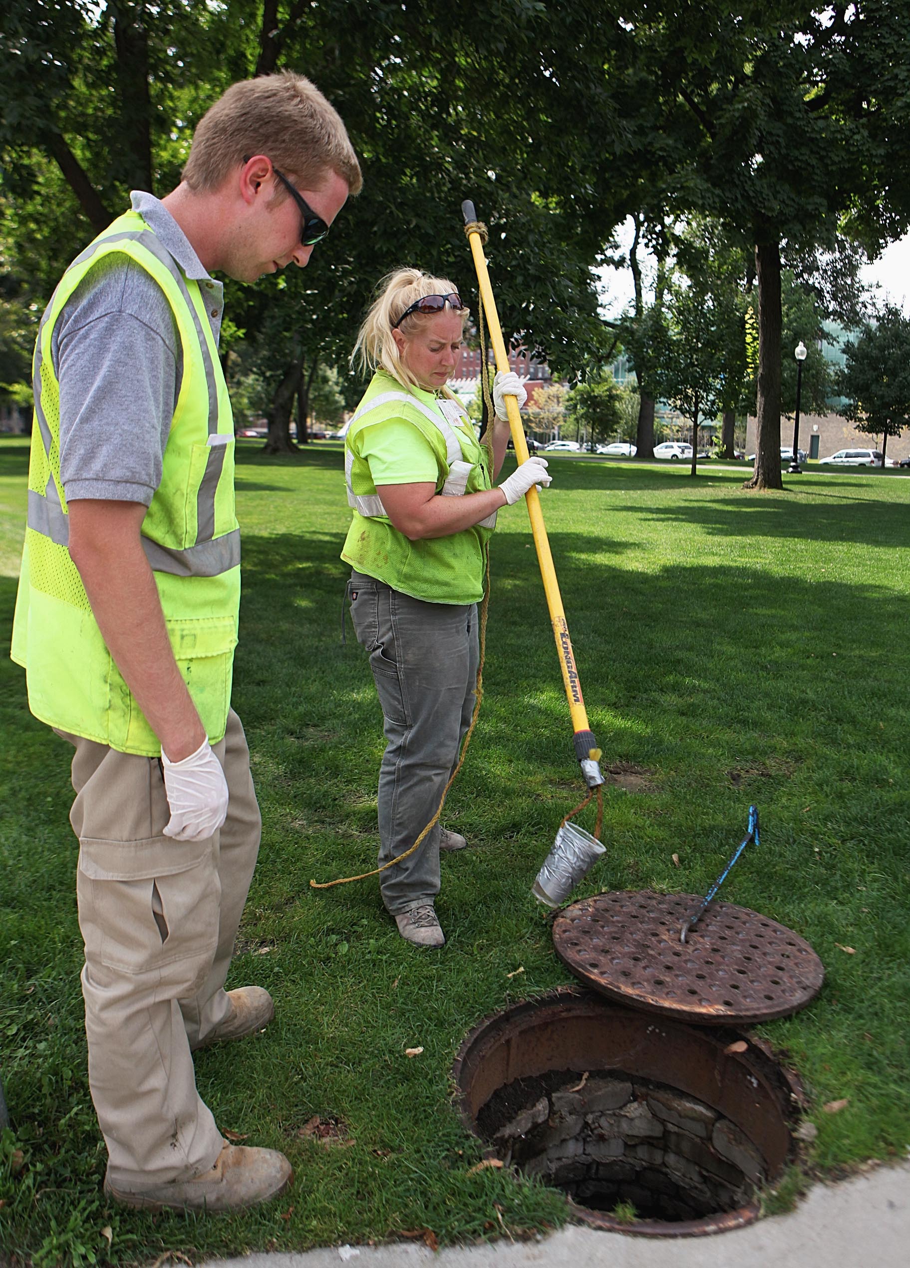 Environmental scientists Lucas Chapman and Emily Coumbassa got stormwater samples at a manhole in the Fenway last week. Finding pollution sources is a painstaking process.