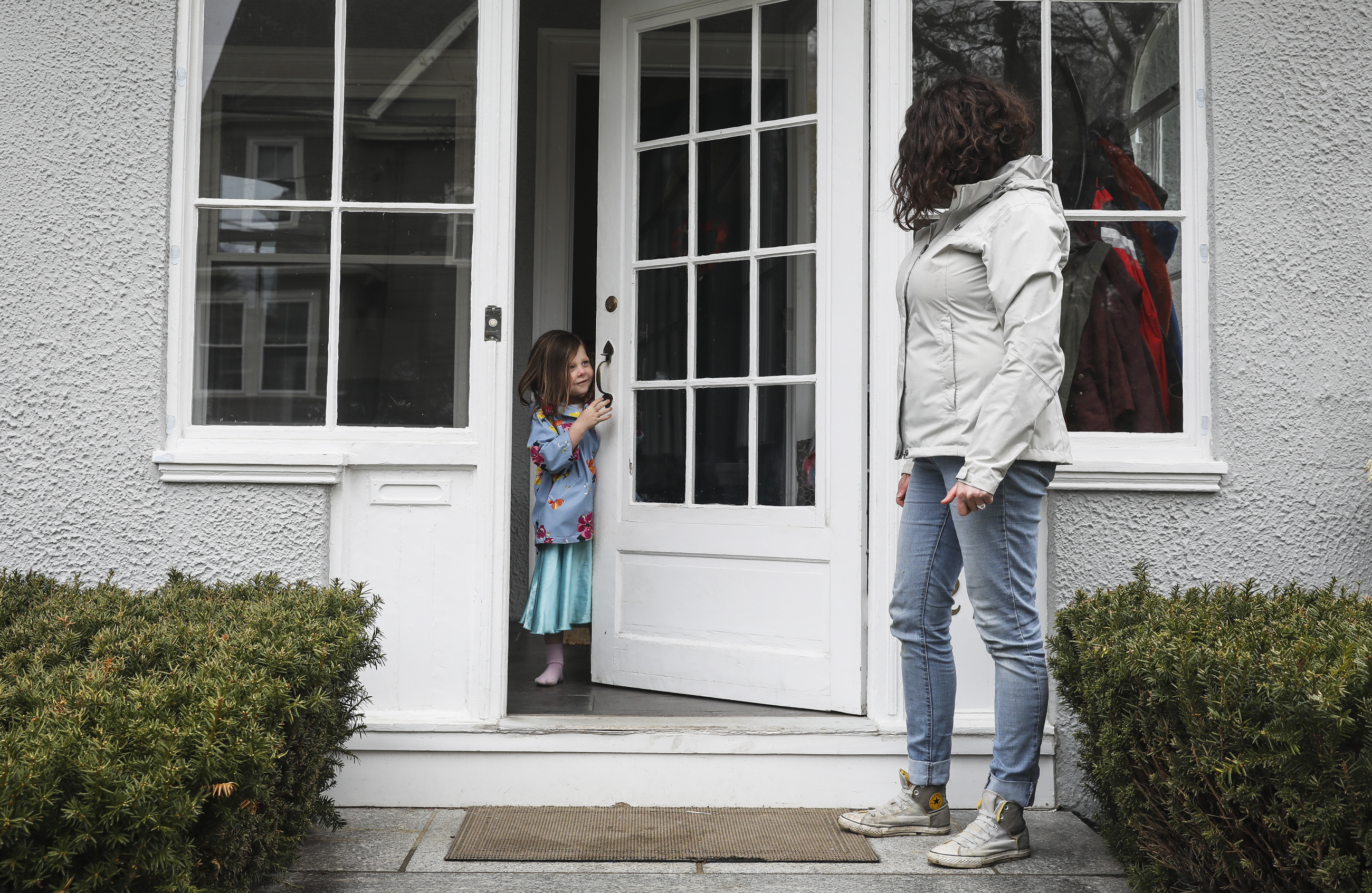 Eila Bradley, 3, poked her head around the front door while spending time with her mom Dana LeWinter at their Melrose home.