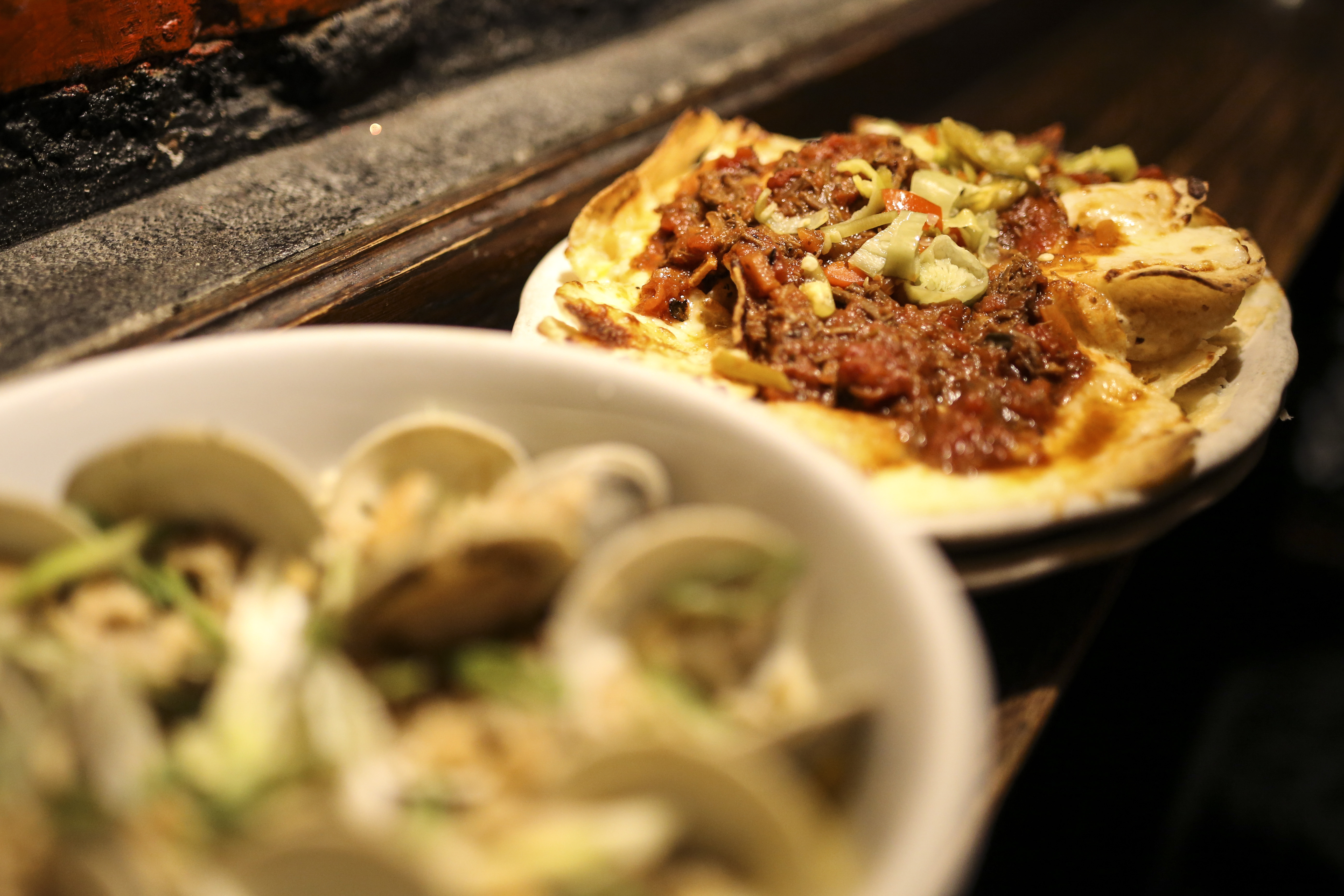 Italian nachos are crisp corn chips topped with braised short-rib ragu, ricotta, and pepperoncini.