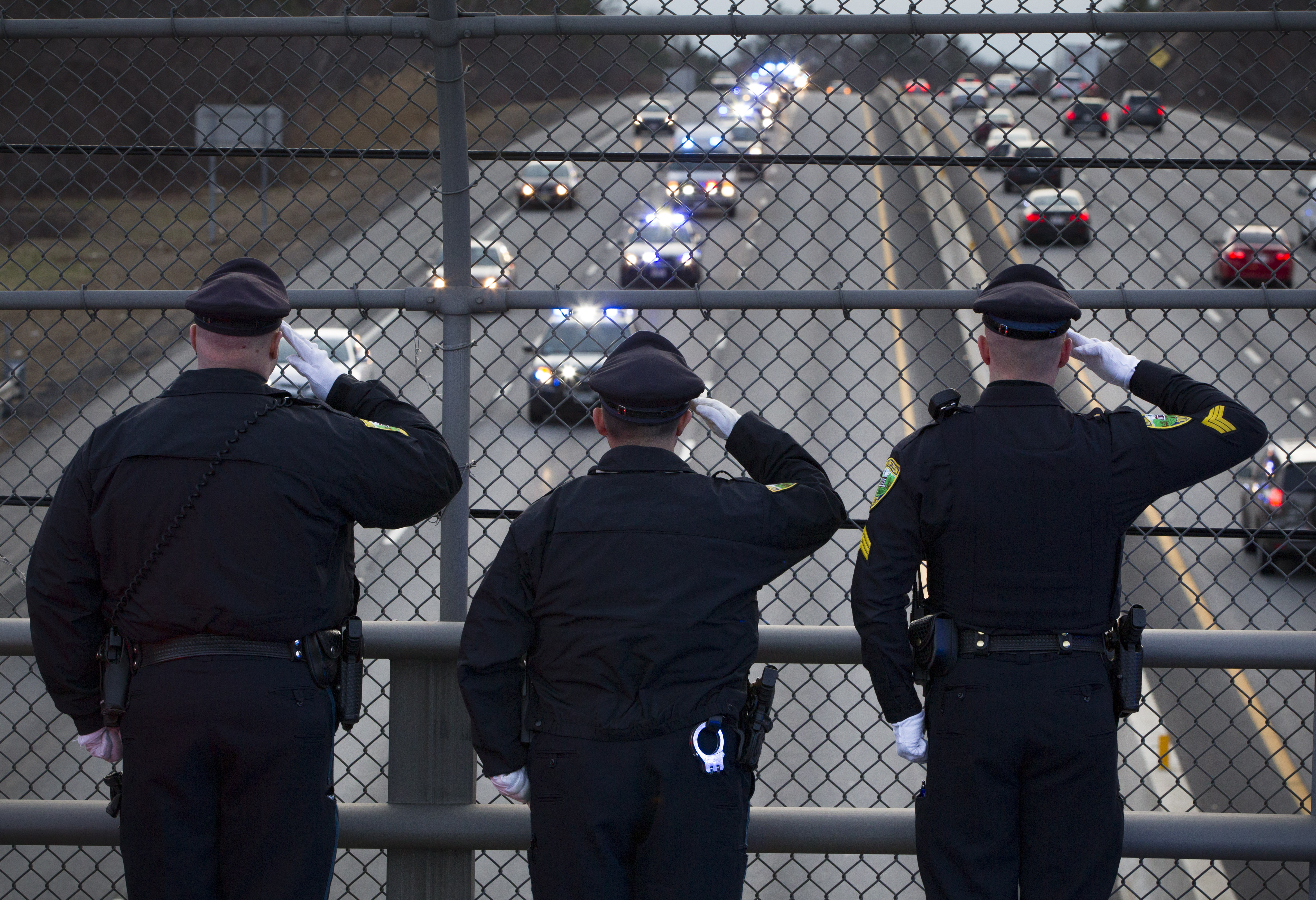 Three Weston police officers saluted as the motorcade escorting Massachusetts State Trooper Thomas Clardy's body passed by on I-90 to the morgue in Boston.