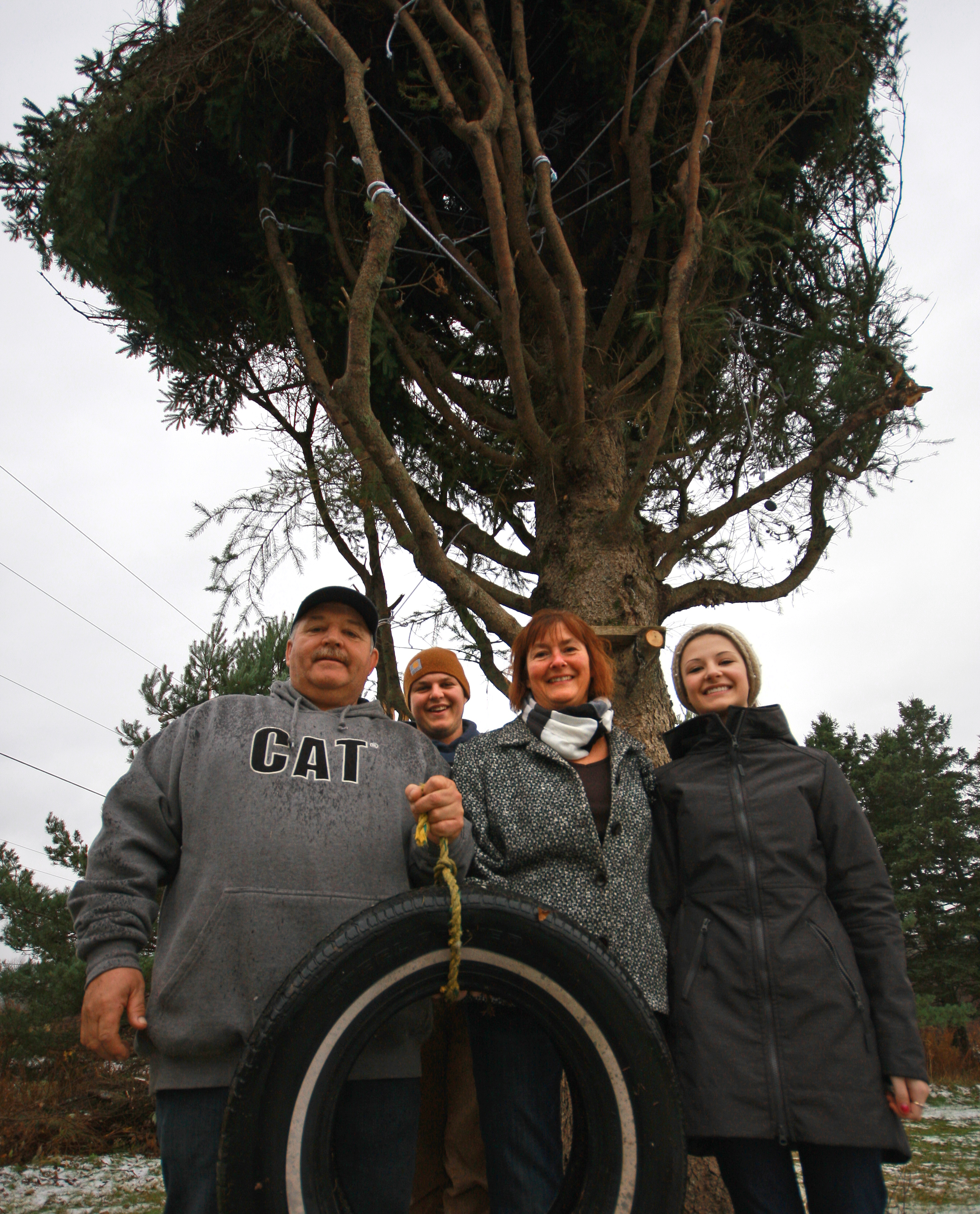 The MacPhersons (from left), John, Tyler, Ethel Ann, and Jessica, with their tree and the old tire swing.
