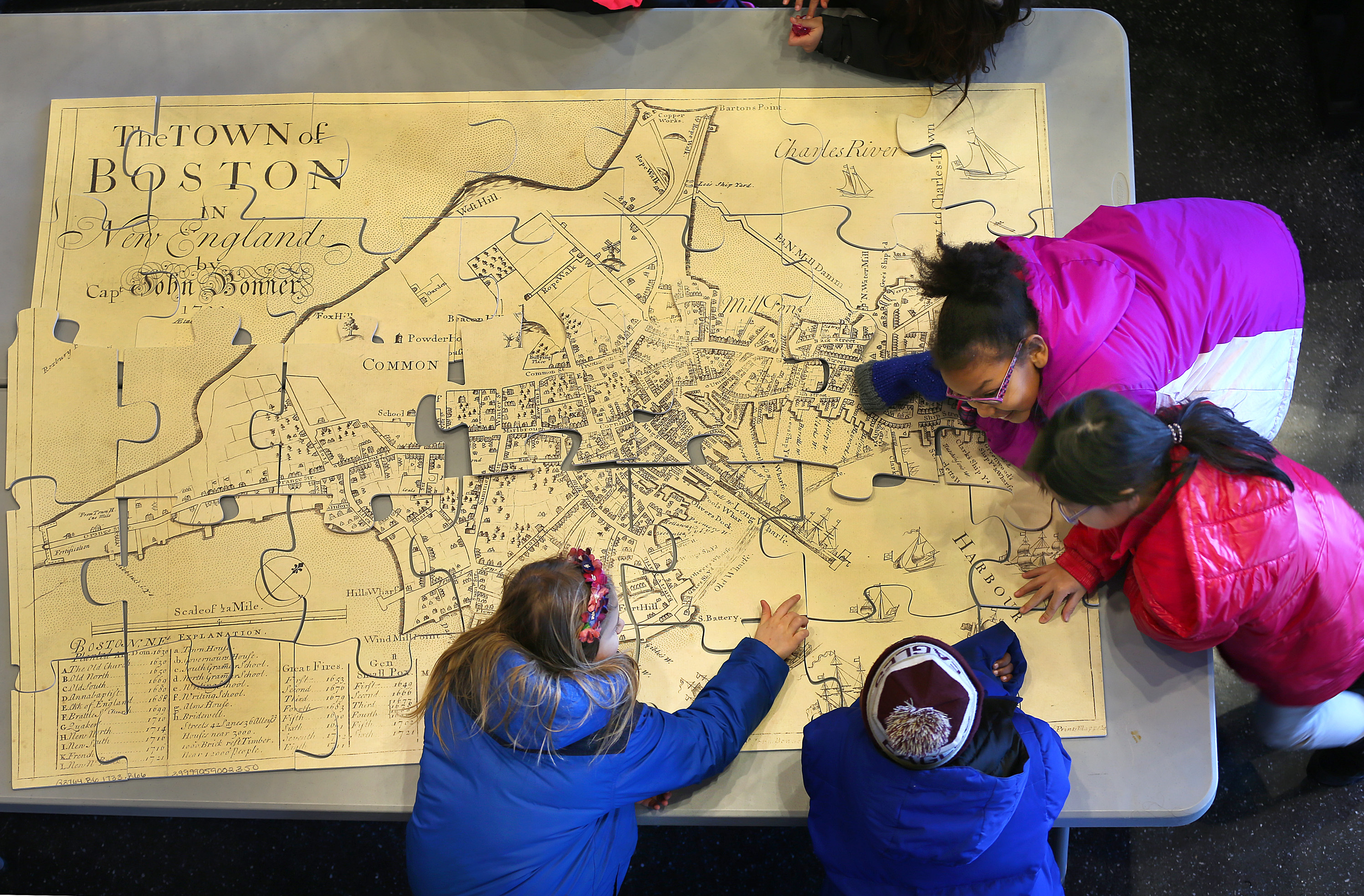 Students put together a puzzle of an old map of Boston at Boston Public School headquarters in Dudley Square.