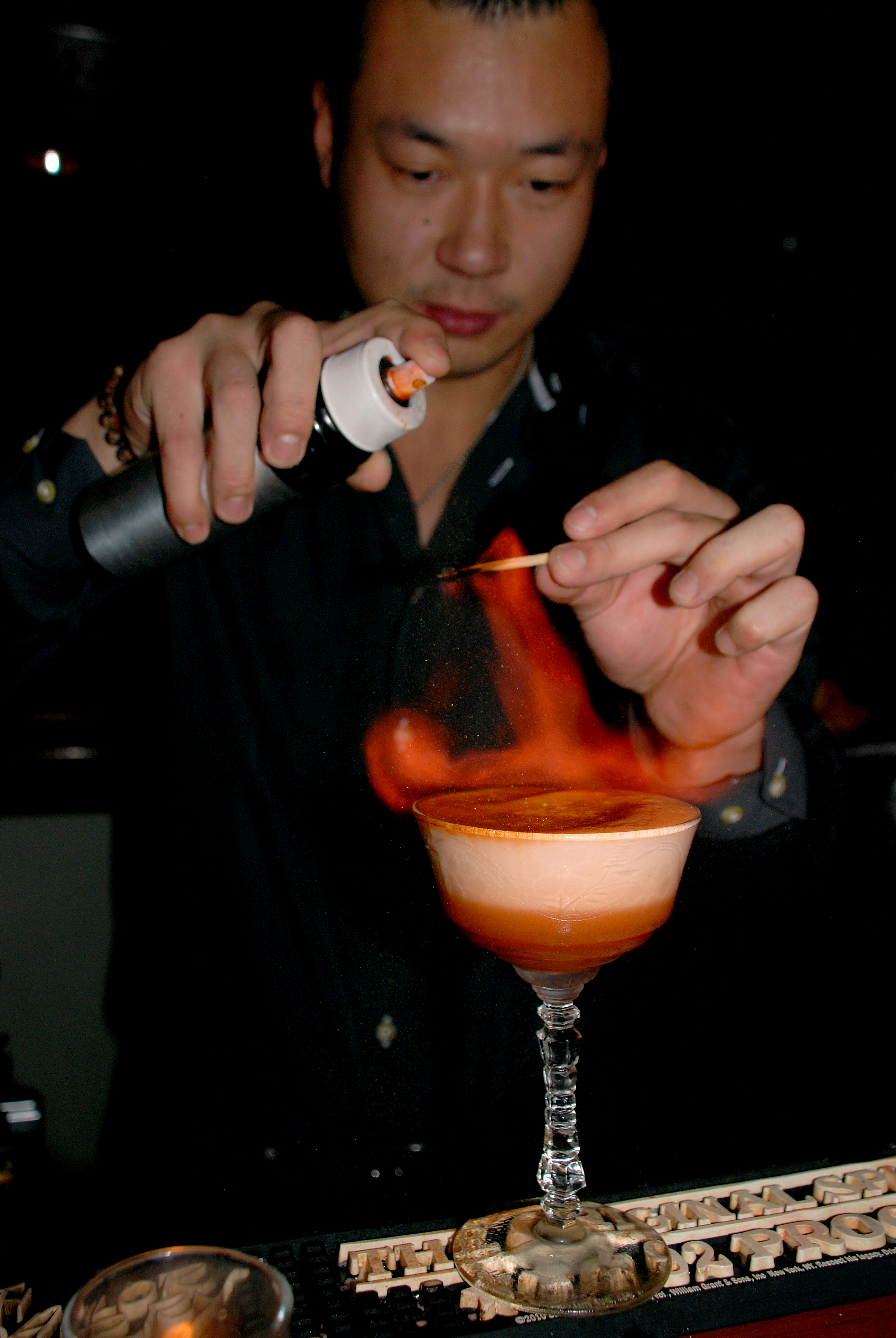 Ran Duan lights a drink on fire before serving it.